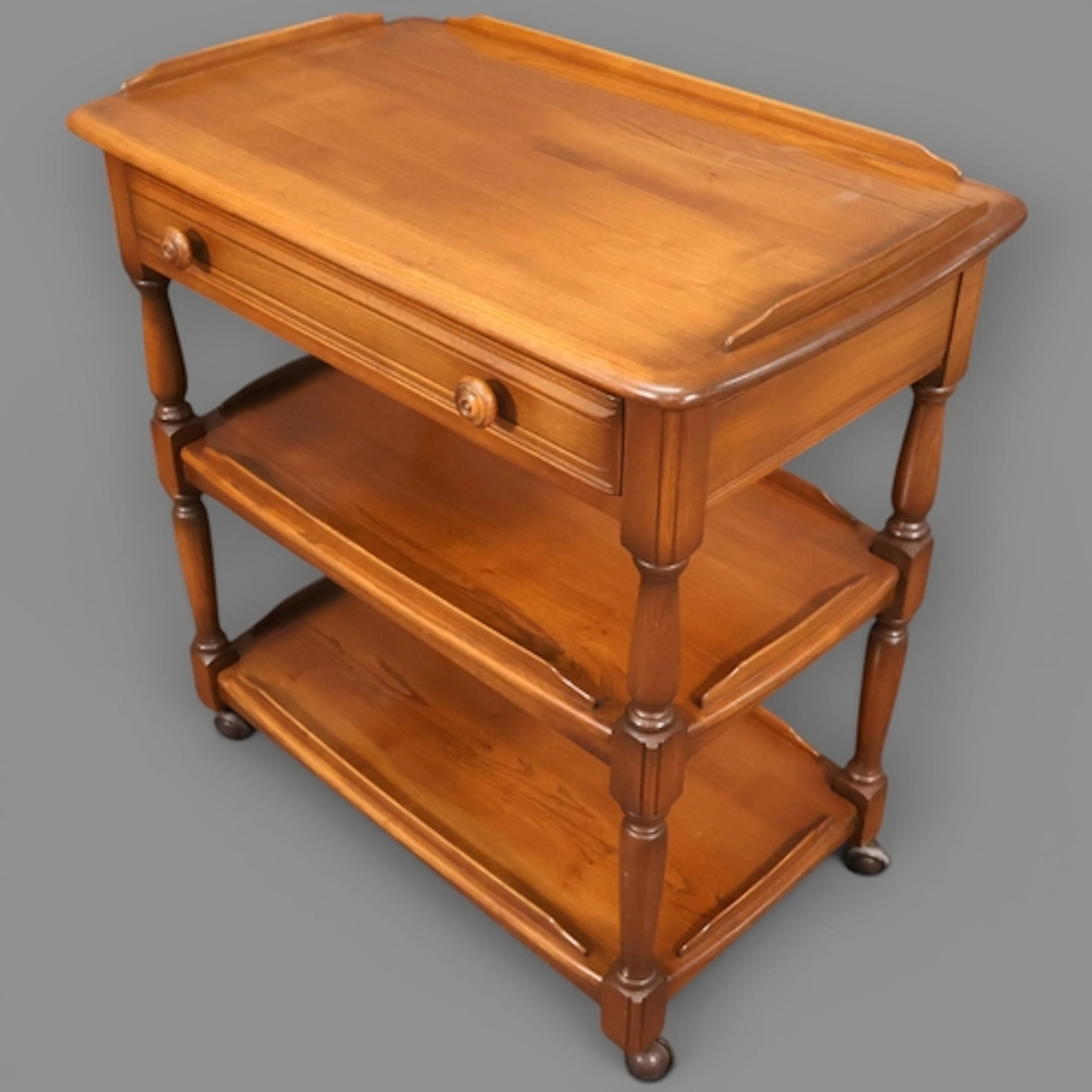 Ercol - a mid 20th century Windsor elm three-tier drinks tro...