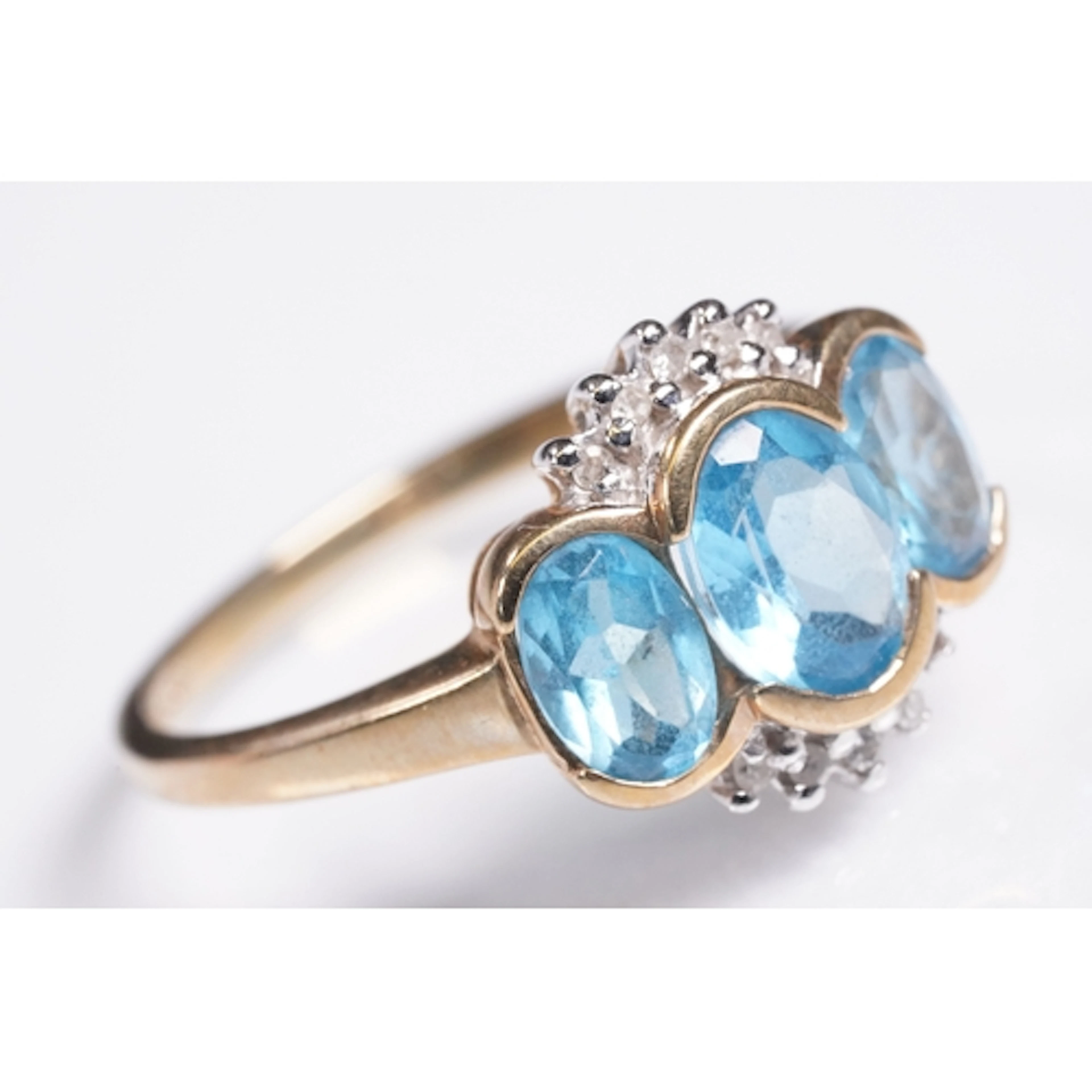 9ct gold, topaz and diamond trilogy ring. The ring being set...