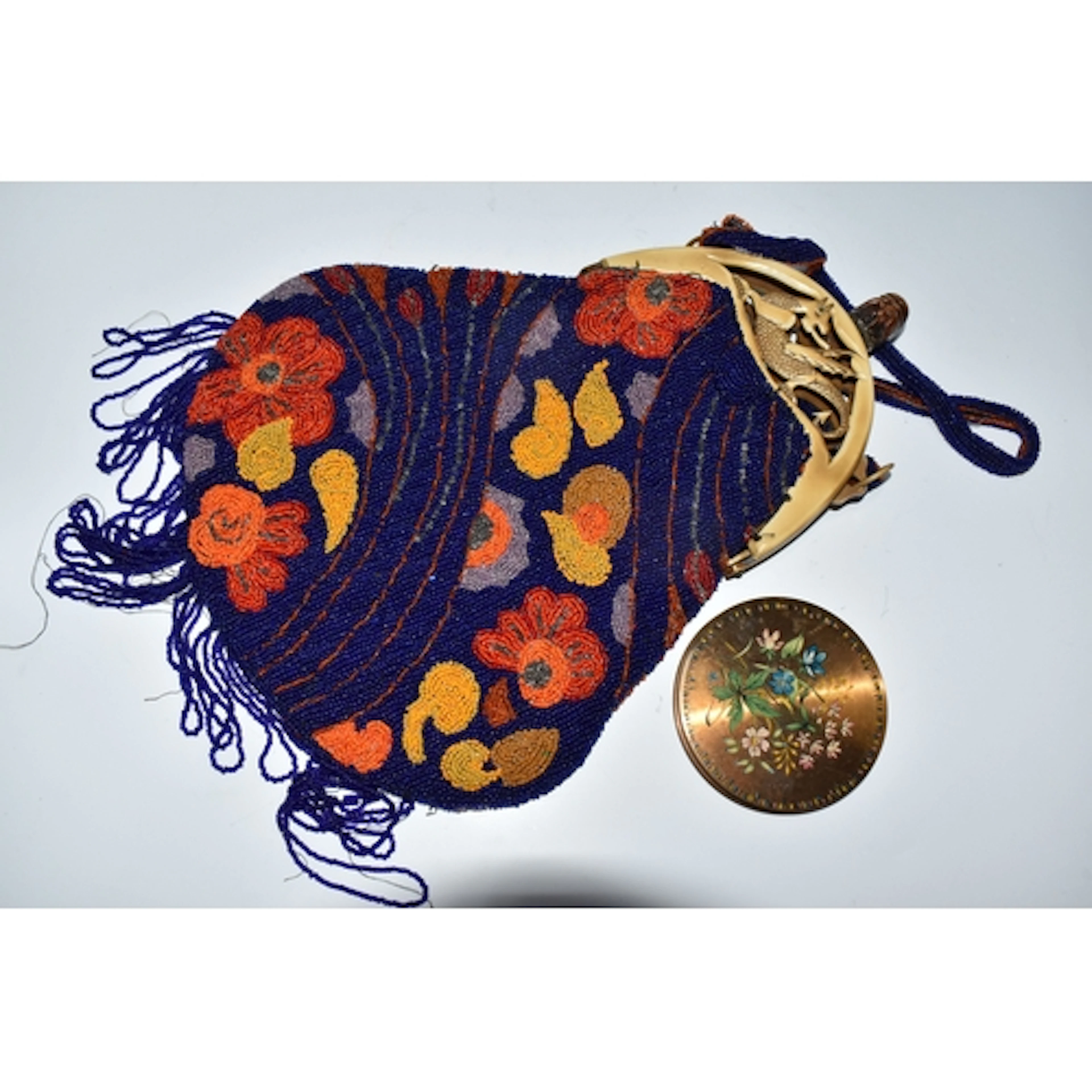 A BEADED EVENING BAG AND COMPACT, the fringed evening bag wi...