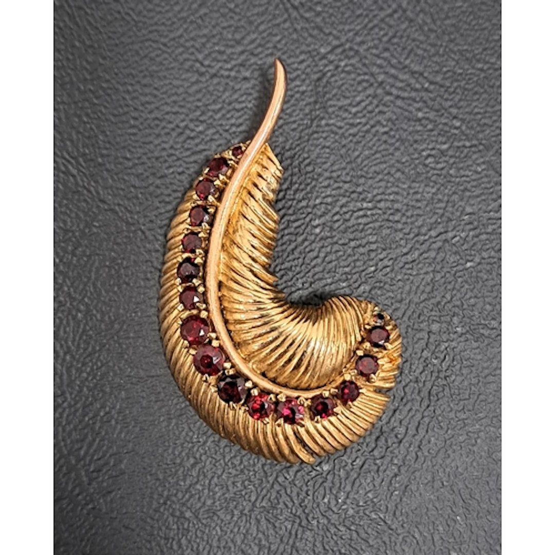GARNET SET NINE CARAT GOLD FEATHER BROOCH the feather with m...
