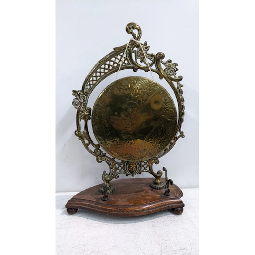 An early 20th century cast brass desk, top dinner gong on an...
