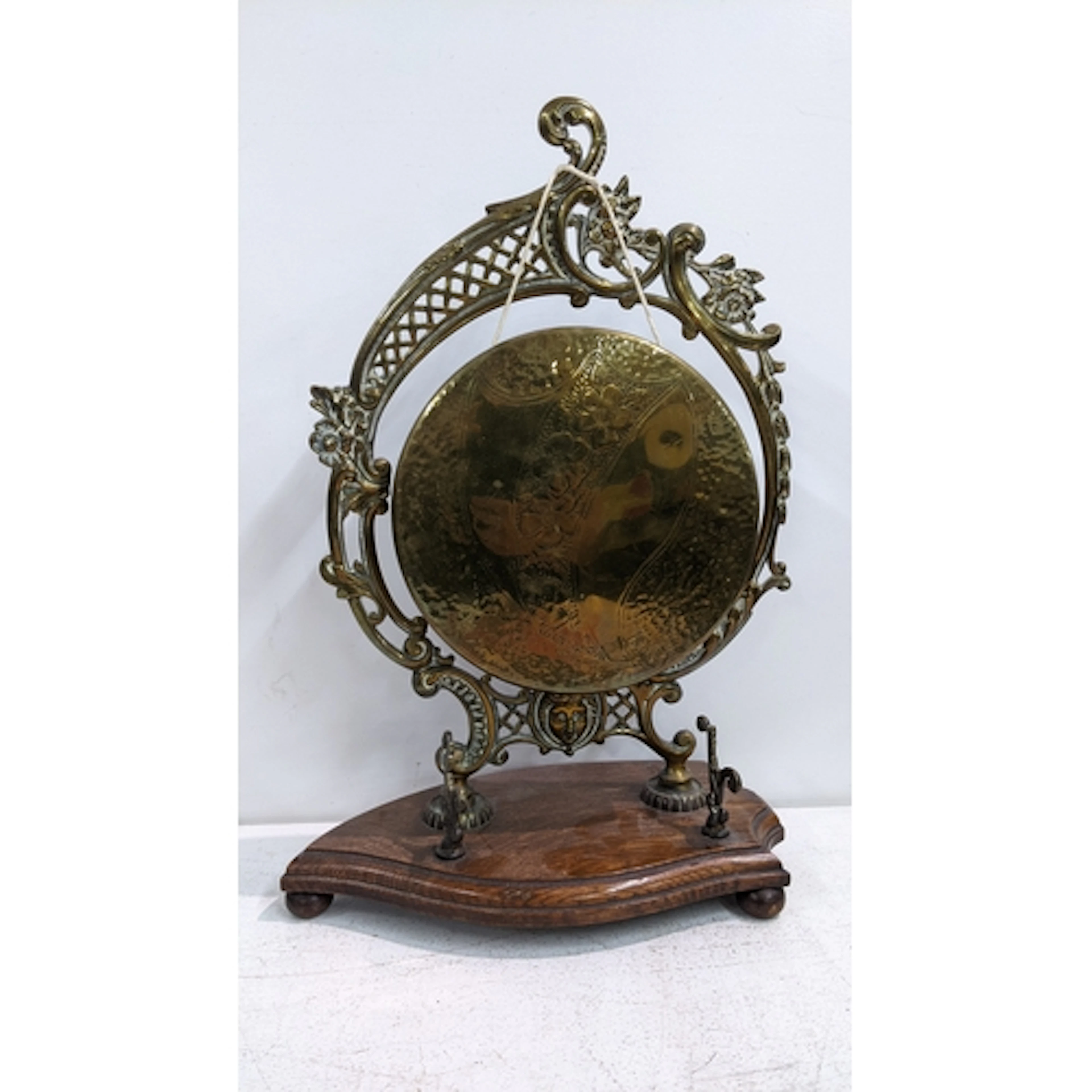 An early 20th century cast brass desk, top dinner gong on an...