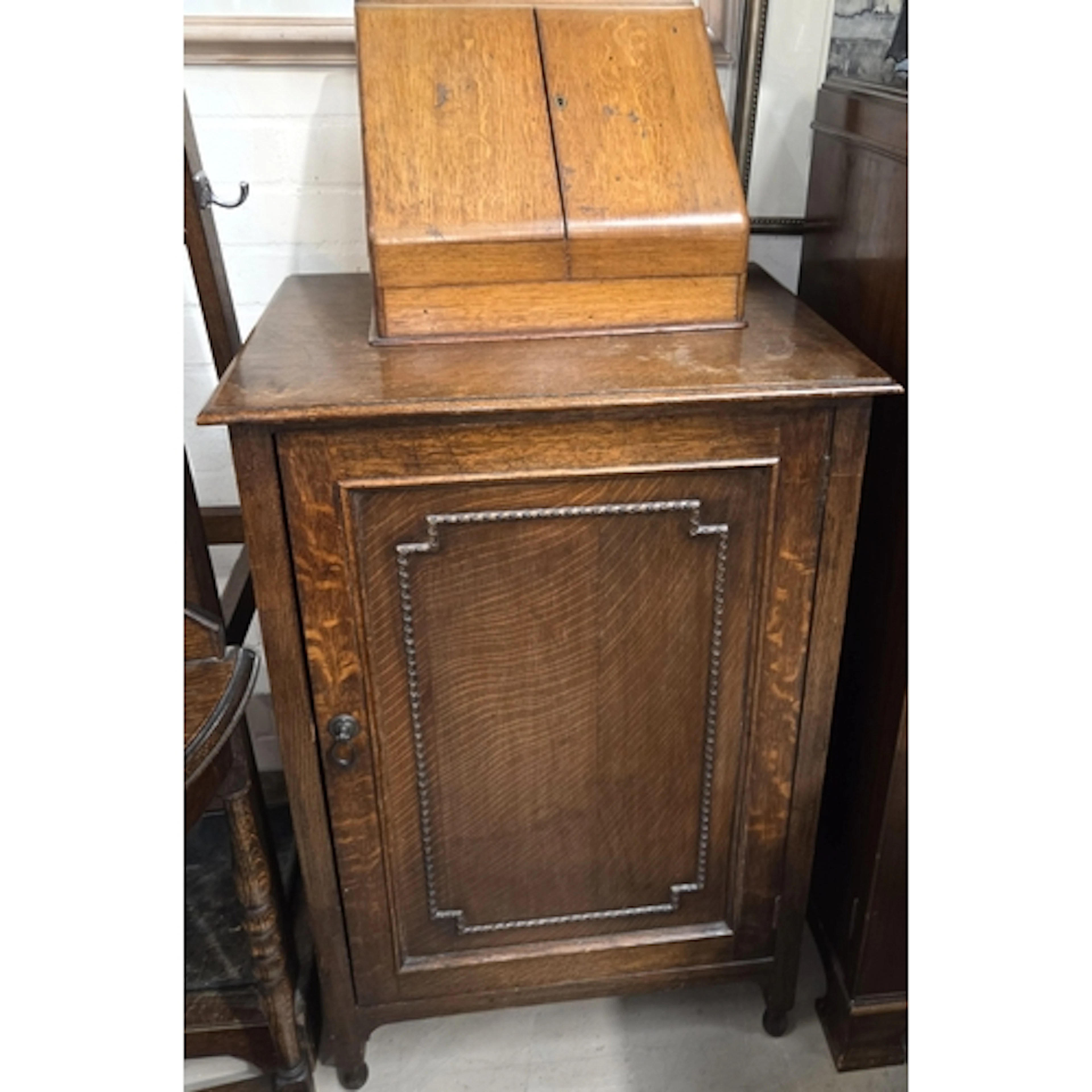 A 1930's oak single door cabinet and a 1930's golden oak slo...