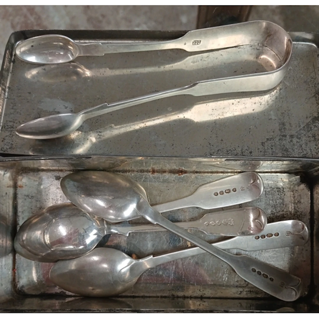 Hallmarked silver spoons and sugar tongs.