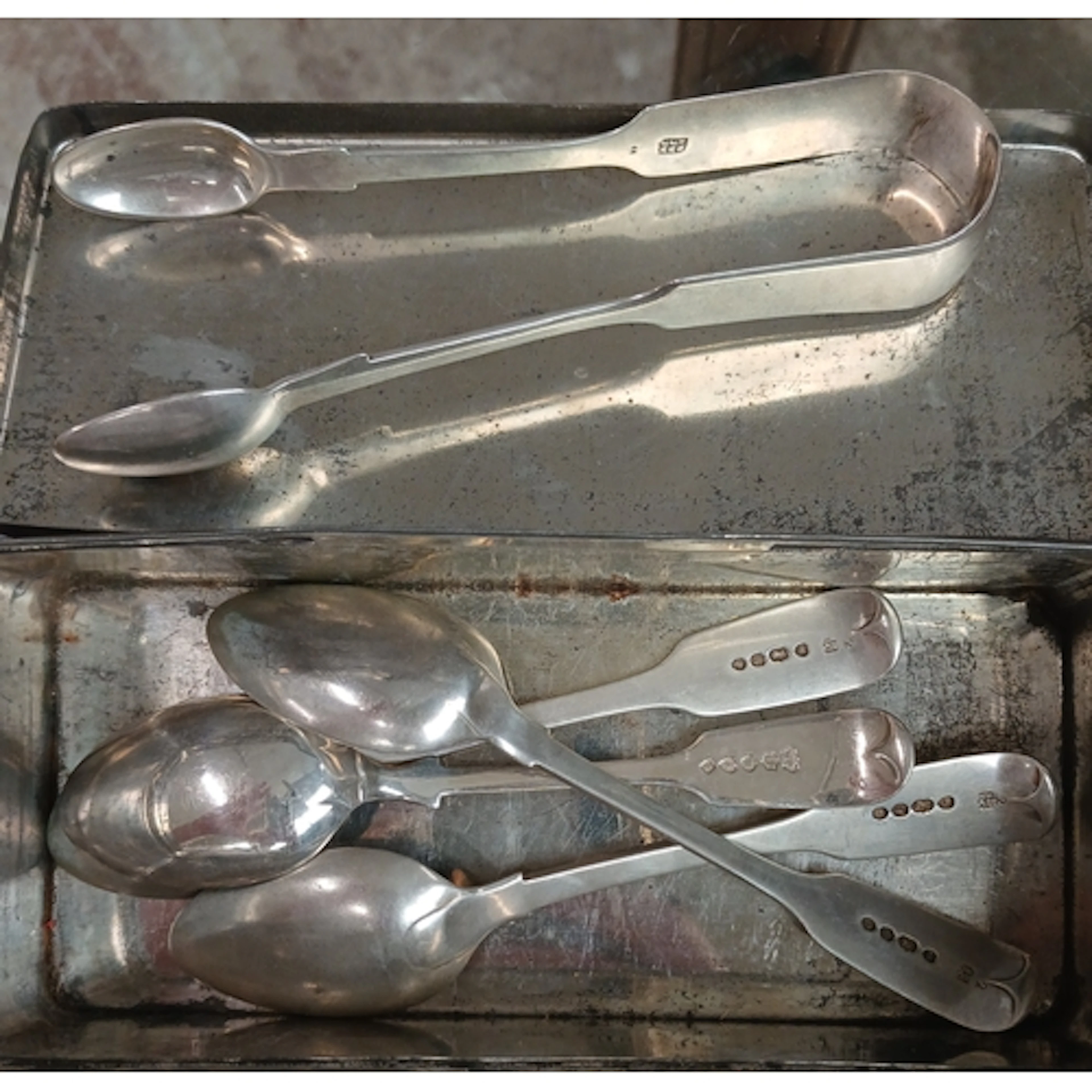 Hallmarked silver spoons and sugar tongs.