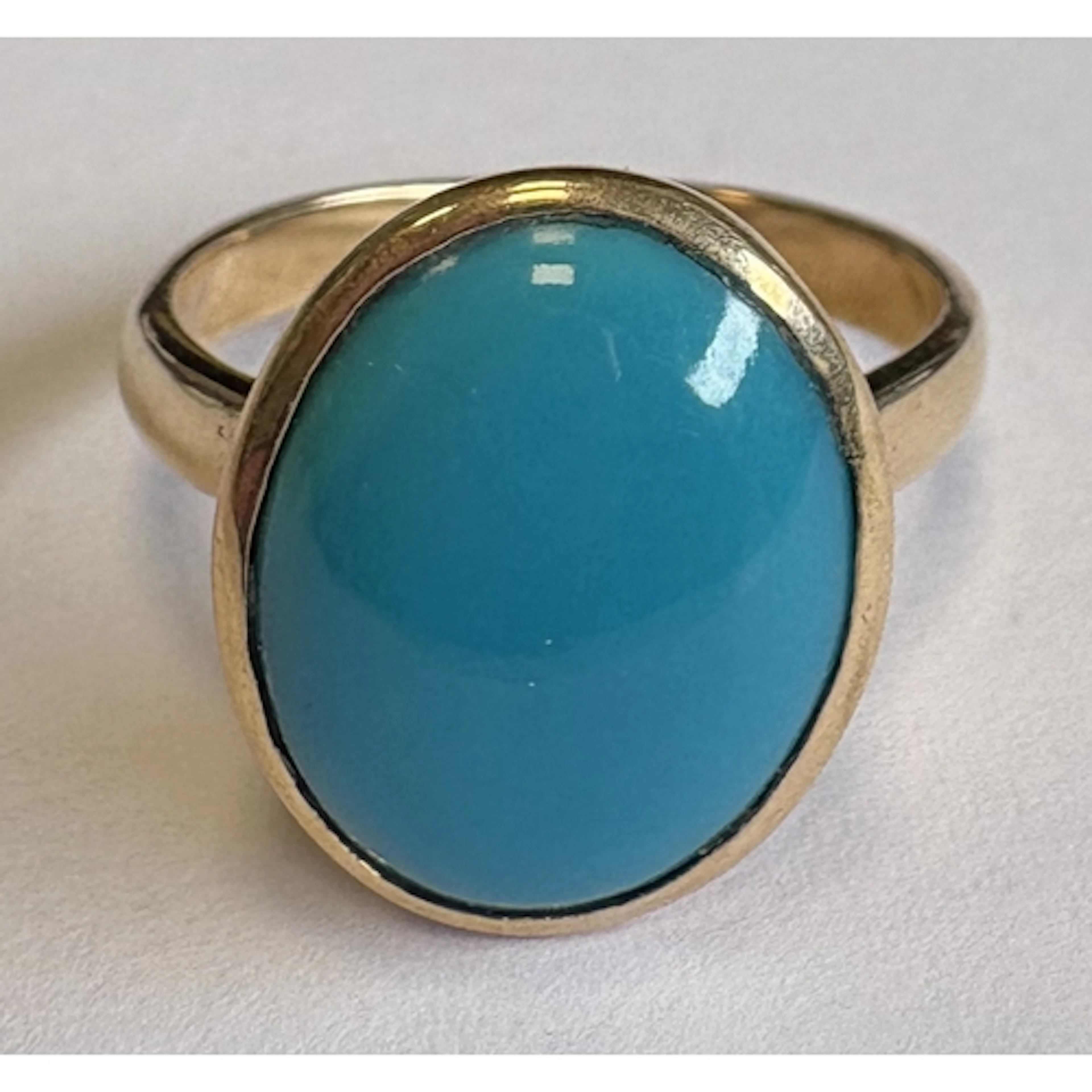 A single-stone turquoise ring set in gold. Approx. ring size...