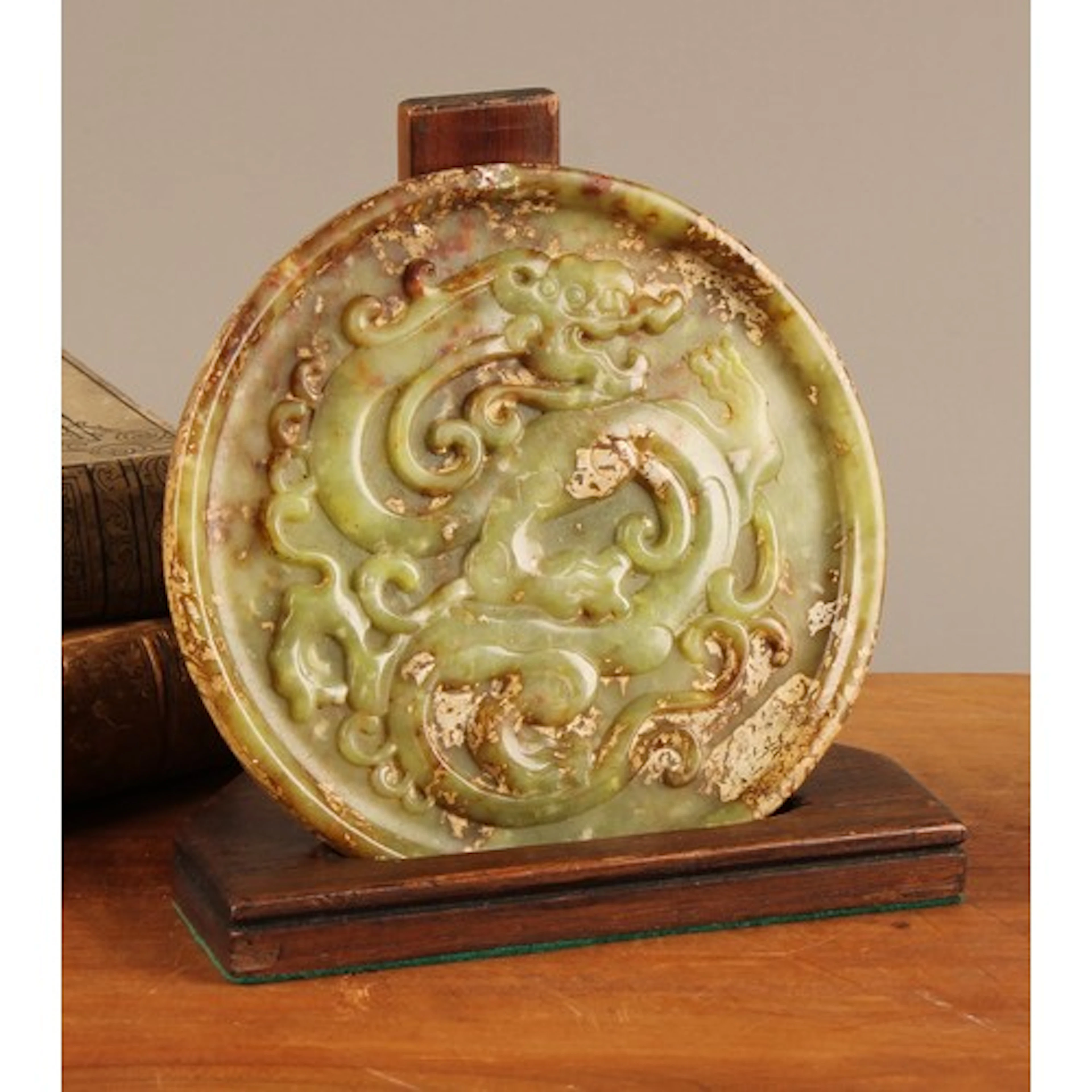 A Chinese jade roundel, carved in relief with a dragon, 15cm...