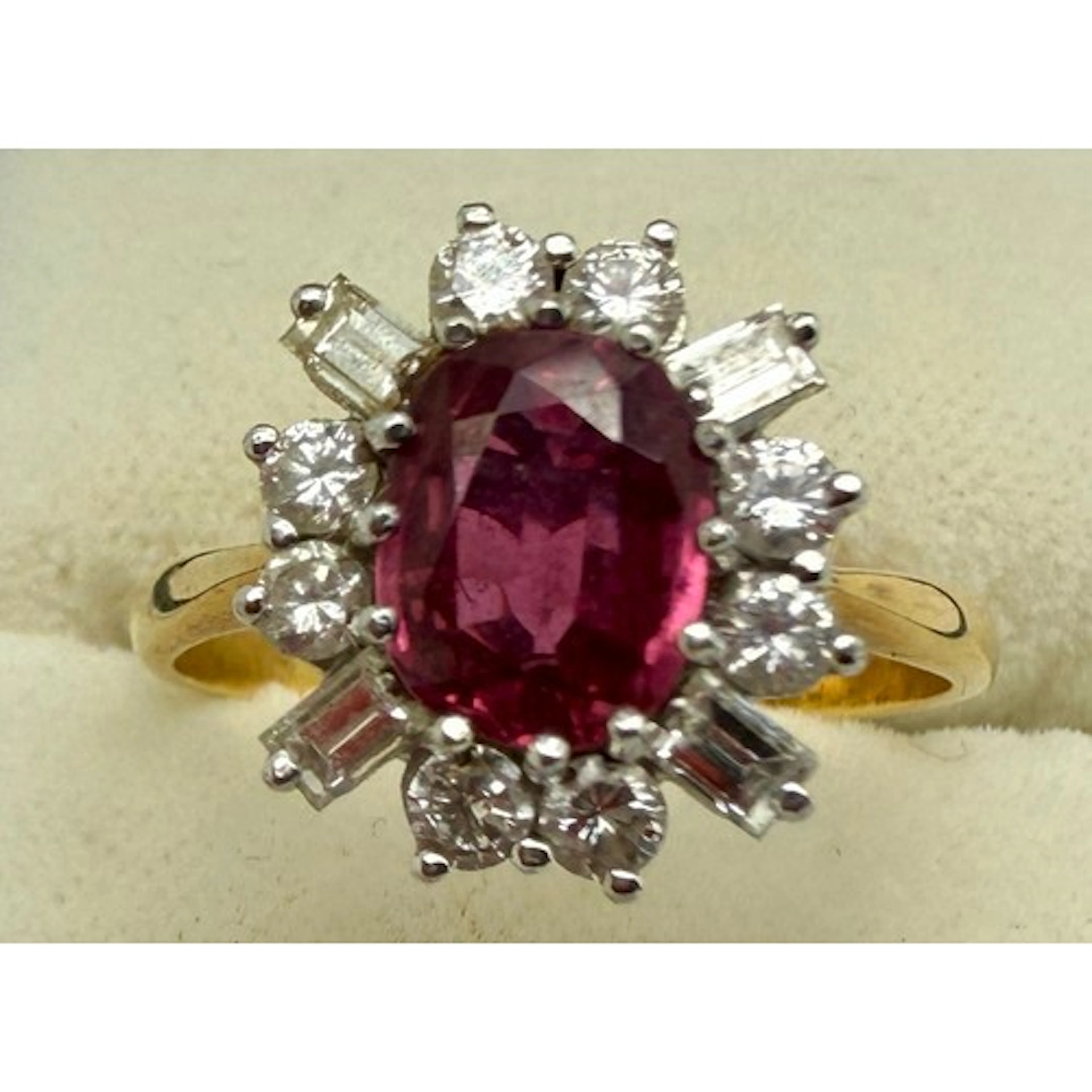 A ruby and diamond cluster ring set in 18 carat yellow gold....