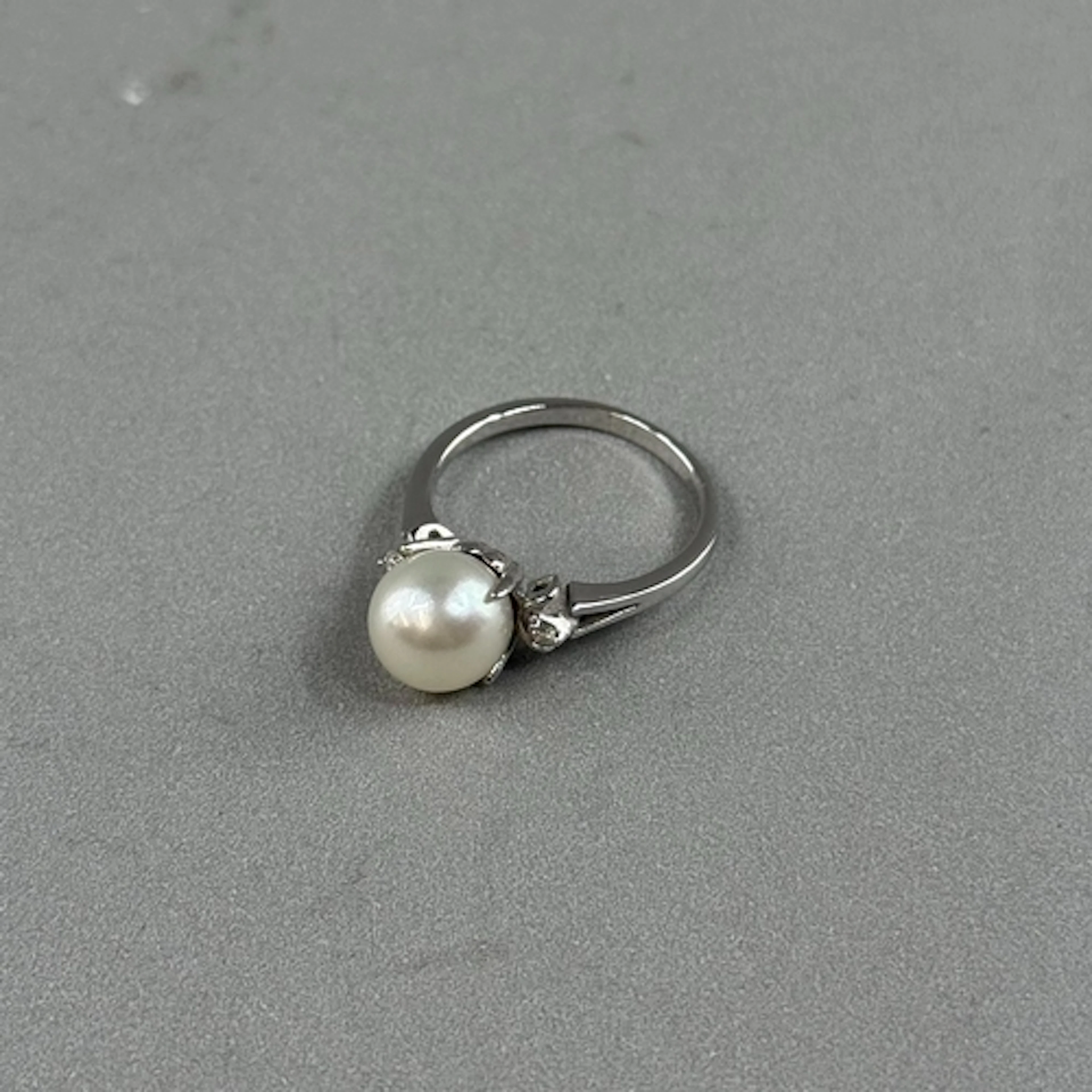 Jewellery: a white metal ring set with a single 8mm cultured...
