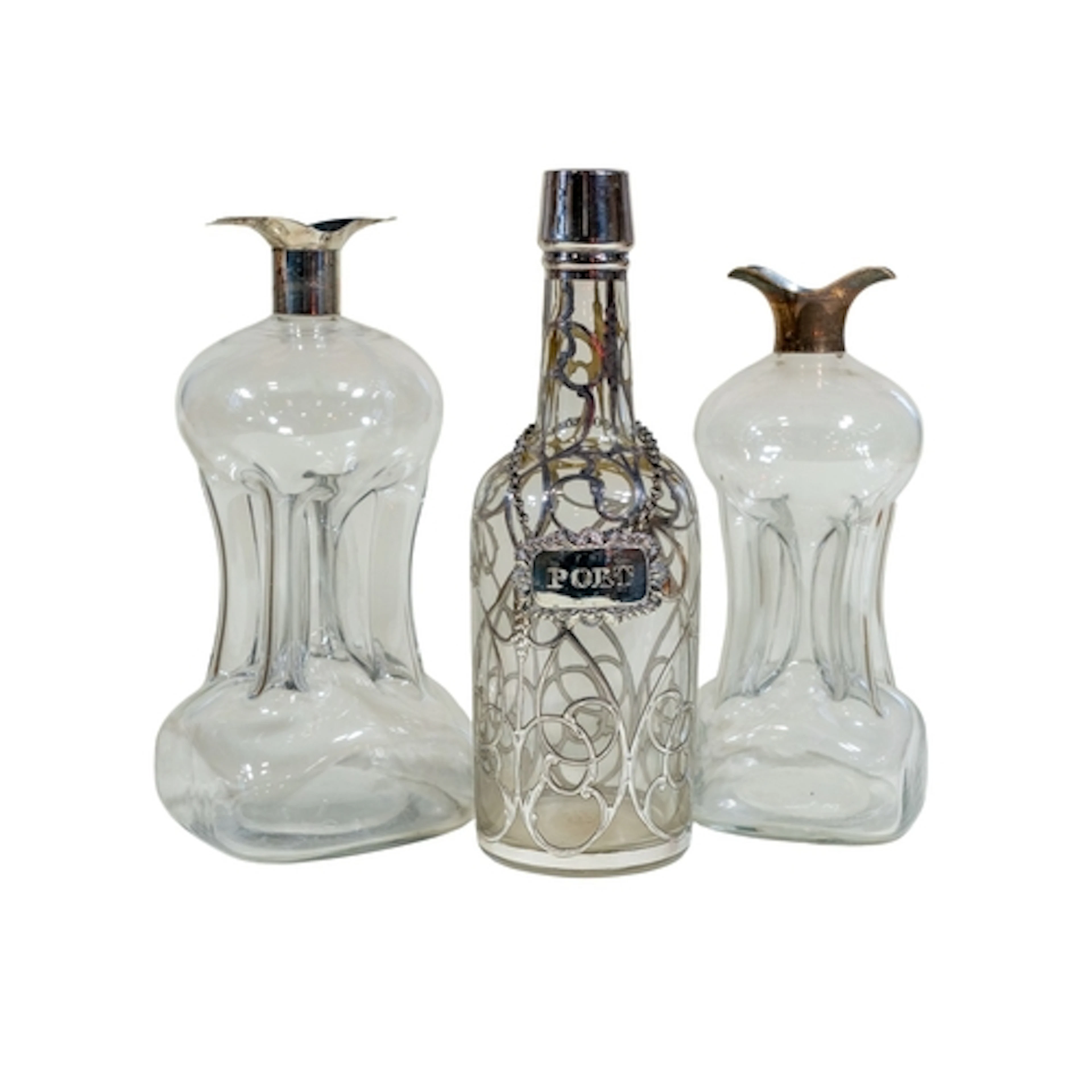 Three clear cut and hand-blown glass decanters, two with sil...