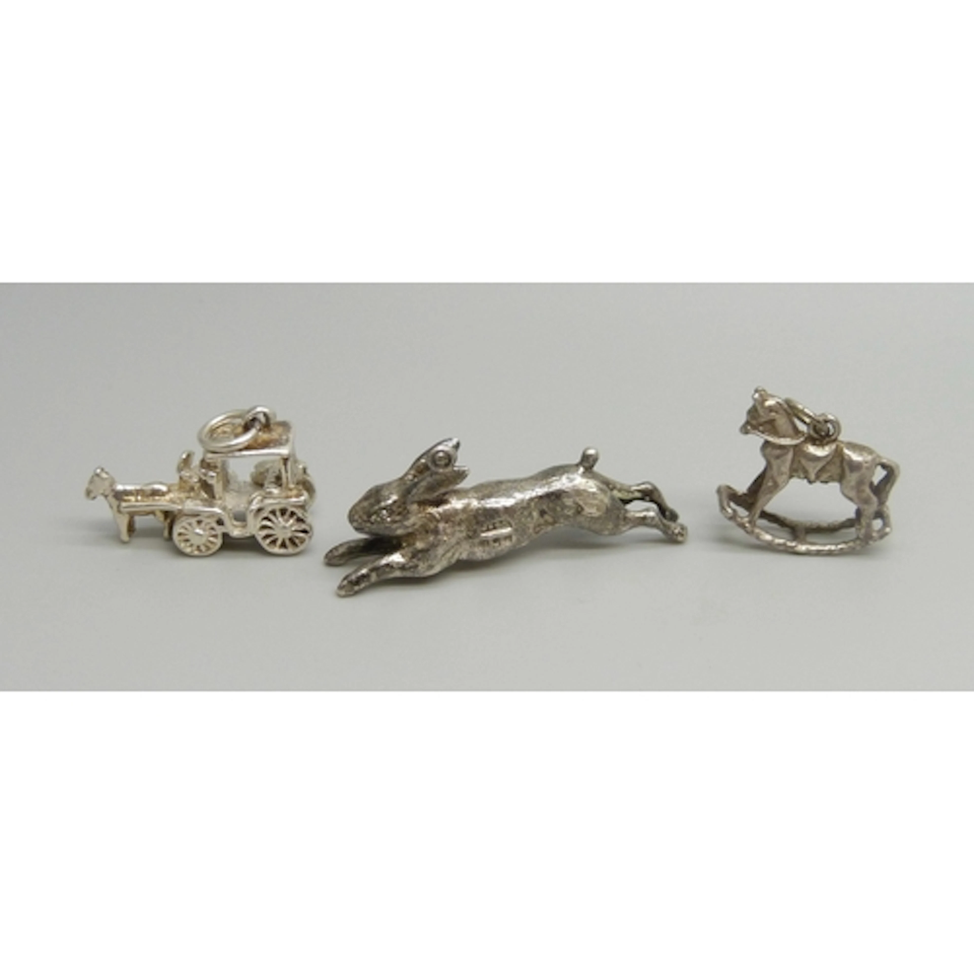A silver charm in the form on a hare, another silver charm, ...