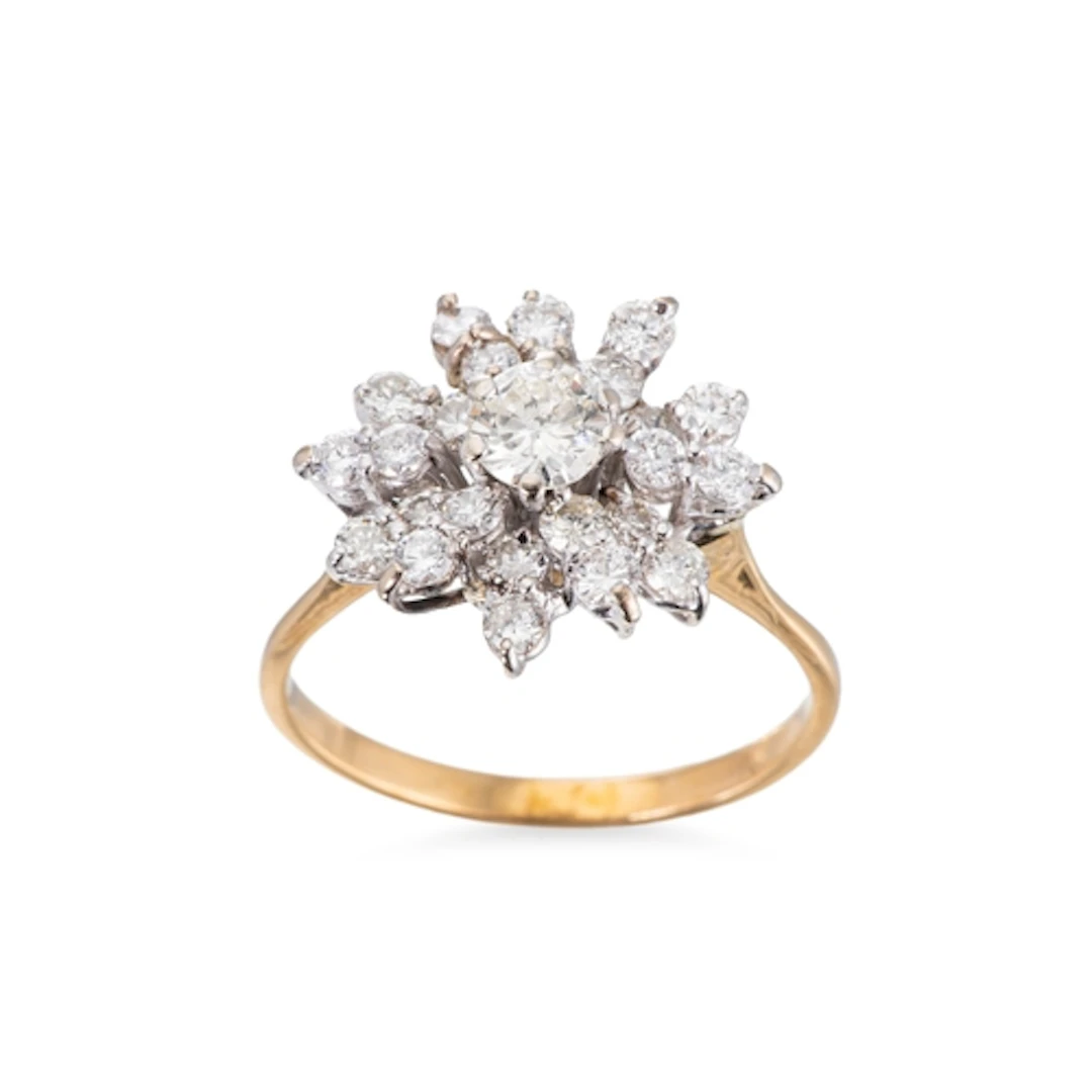 A DIAMOND CLUSTER RING, the brilliant cut diamond to stepped...