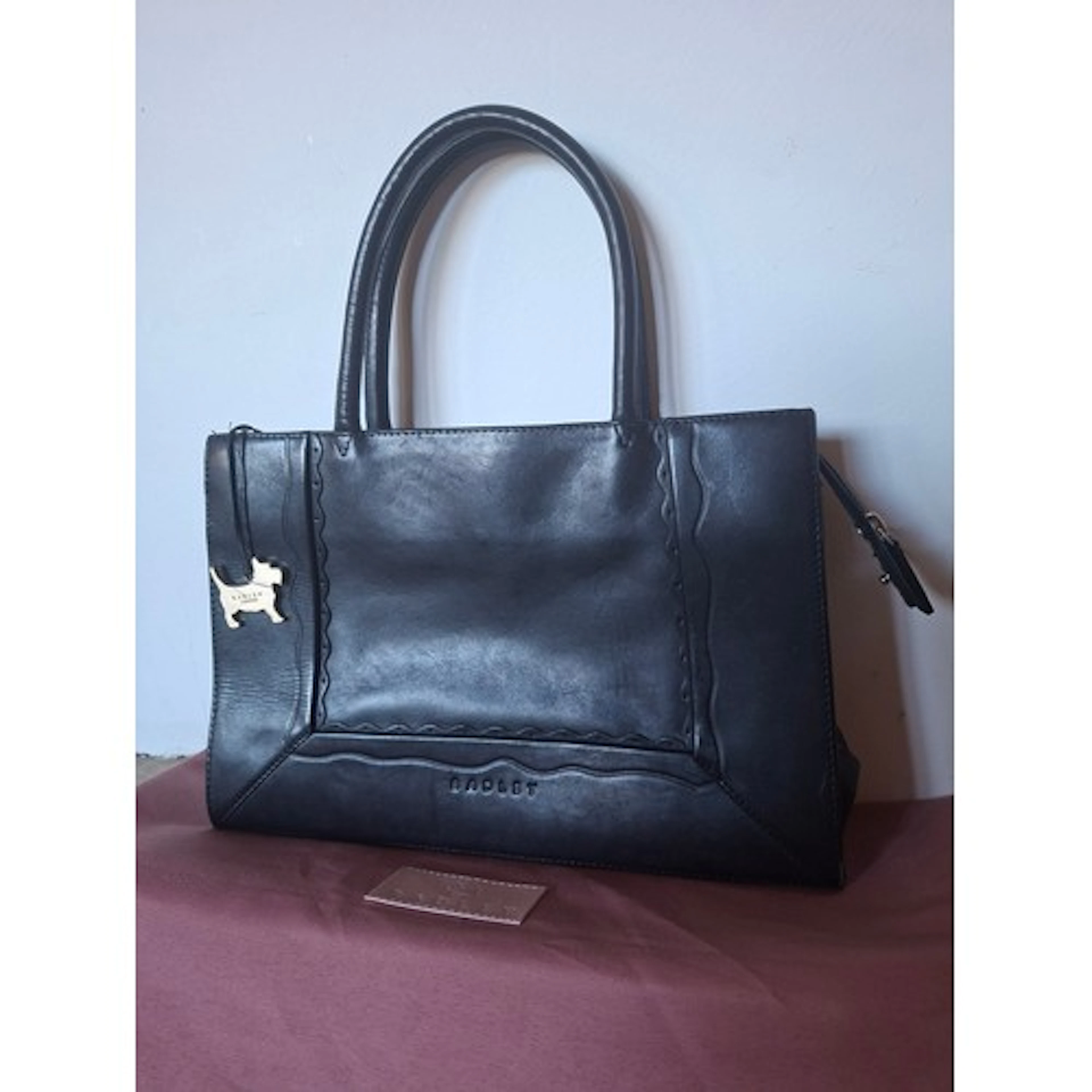 Radley- A black leather handbag having a gold metallic dog t...