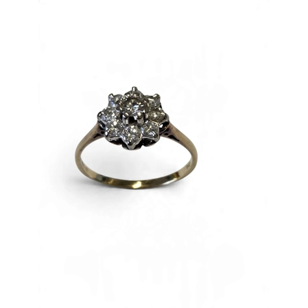 A lovely 18-carat gold nine-stone diamond cluster ring, the ...