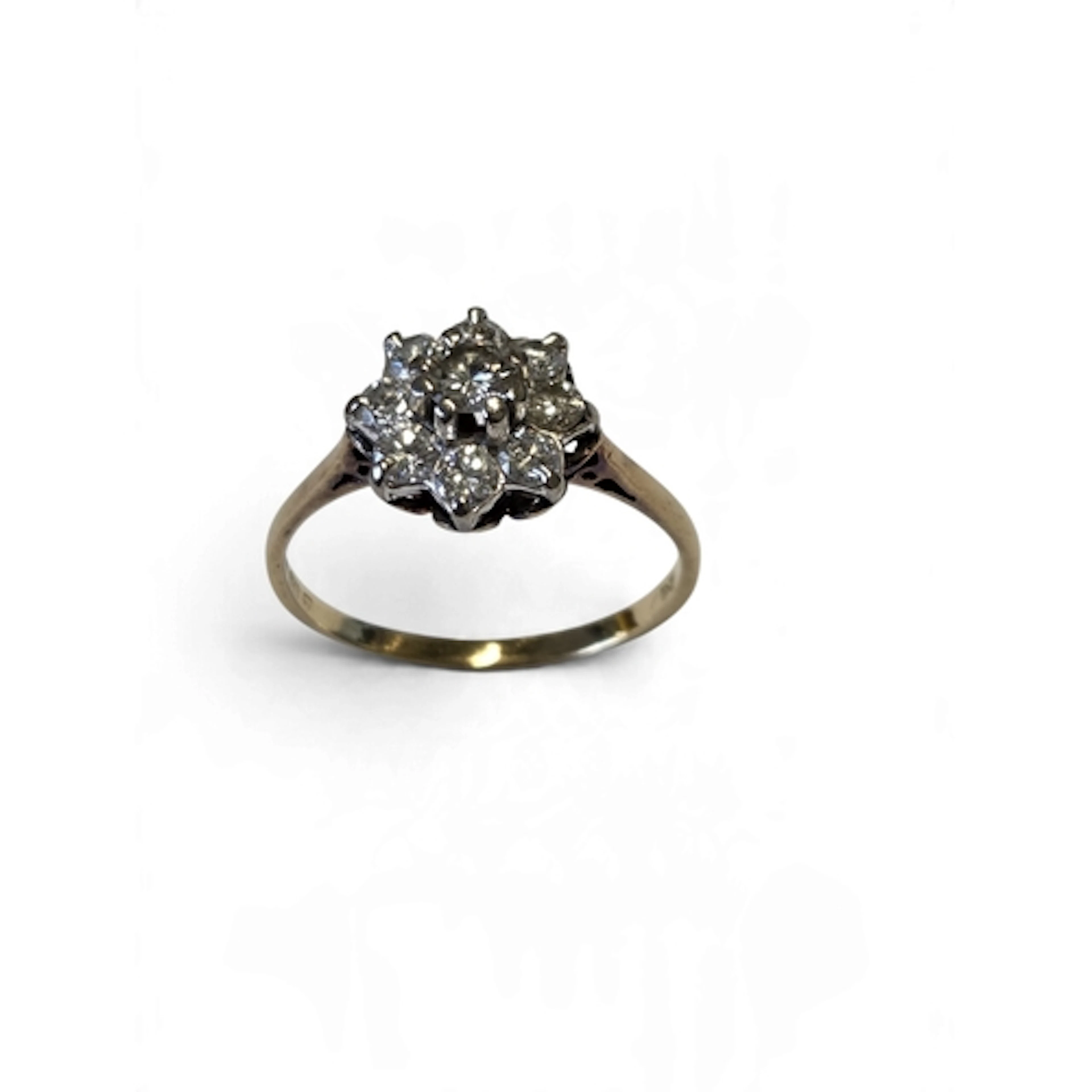 A lovely 18-carat gold nine-stone diamond cluster ring, the ...