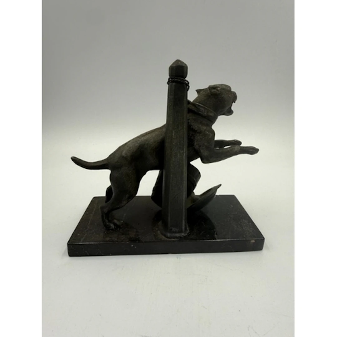 A bronze sculpture of a tethered guard dog on marble plinth....
