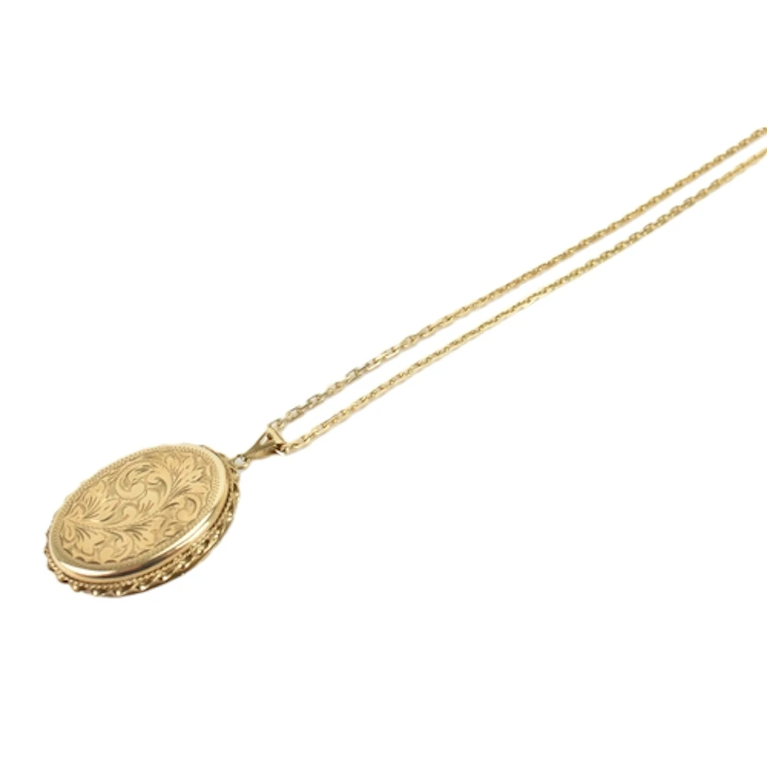A 9ct yellow gold locket and chain, the locket engraved with...