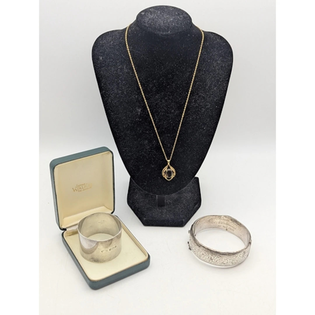 A 9ct yellow gold and smoky quartz pendant, featuring an ova...