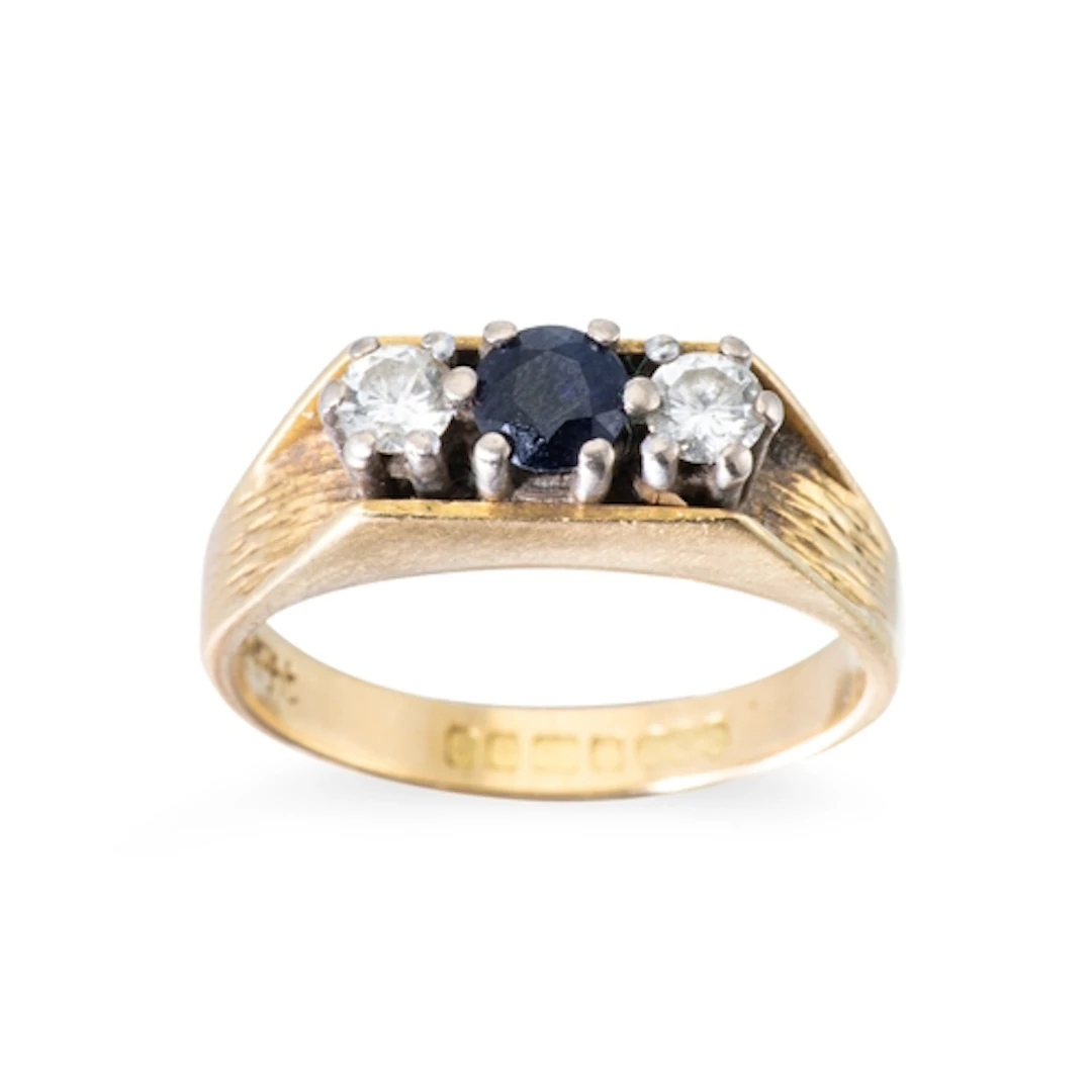 A SAPPHIRE AND DIAMOND THREE STONE RING, the round sapphire ...