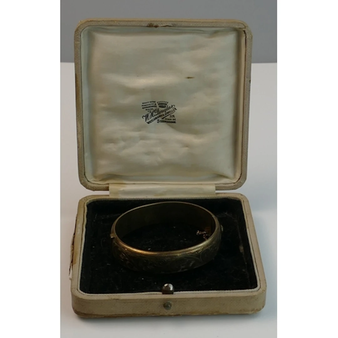 A silver hinged bangle with chased foliate decoration, hallm...