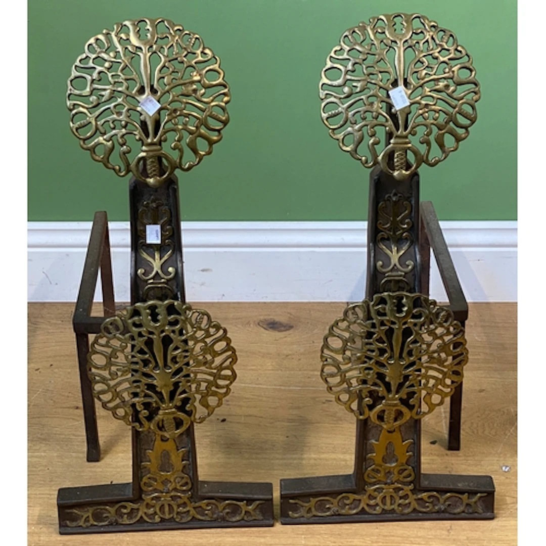 A pair of Arts & Crafts brass and cast iron fire dogs in the...