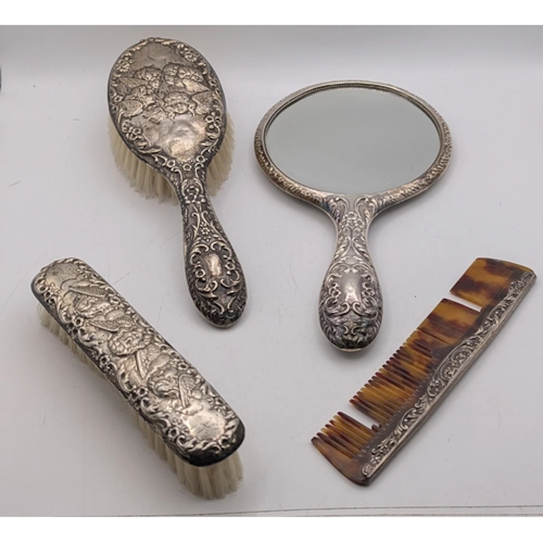 A four piece dressing table set to include two brushes, a co...