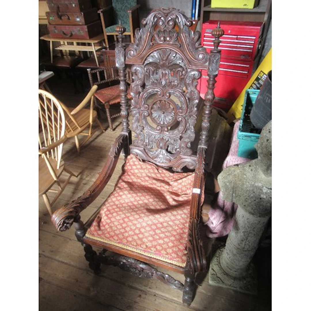 A large antique open arm chair having carved decoration all ...