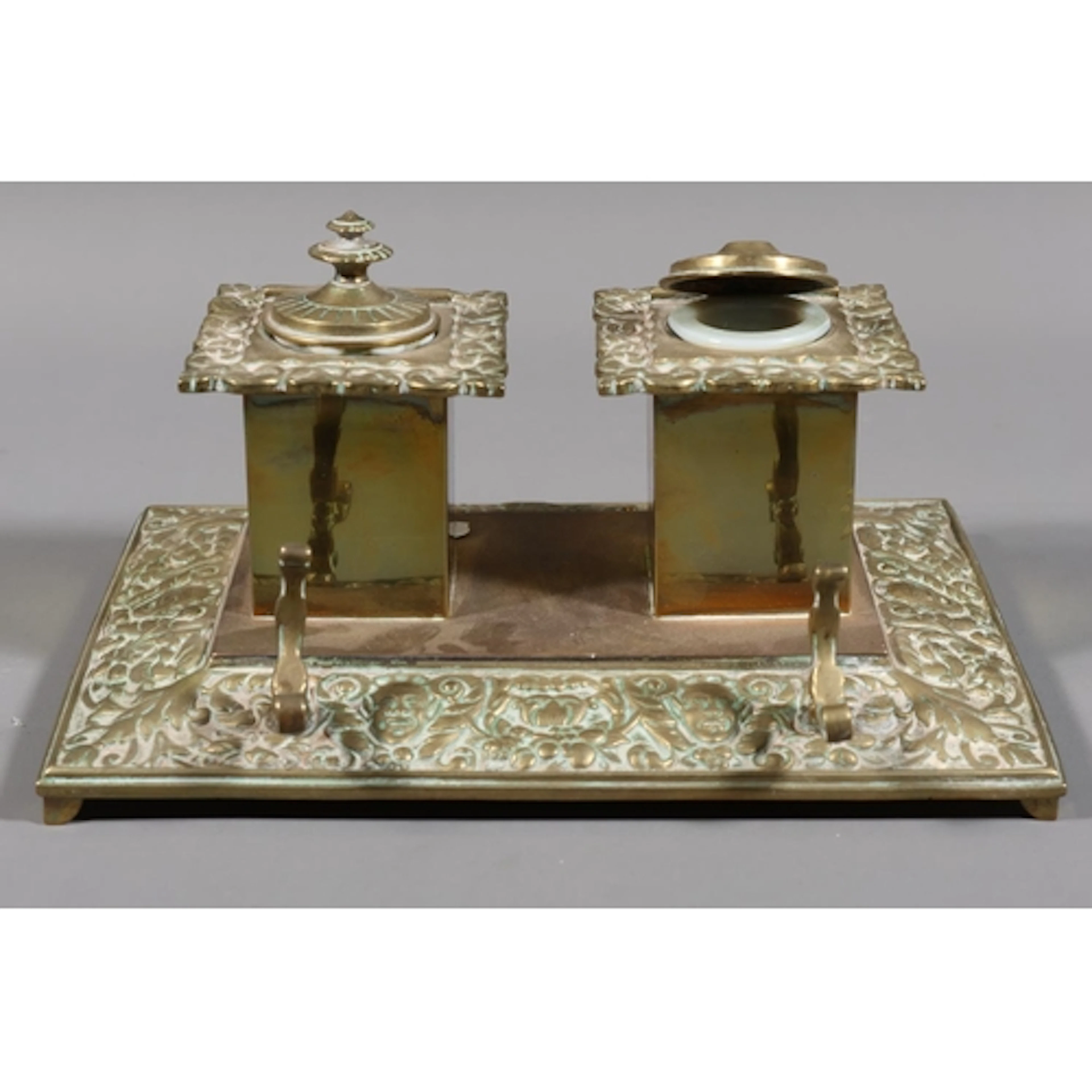 Brass desk inkwell comprising two square inkwells on mask an...