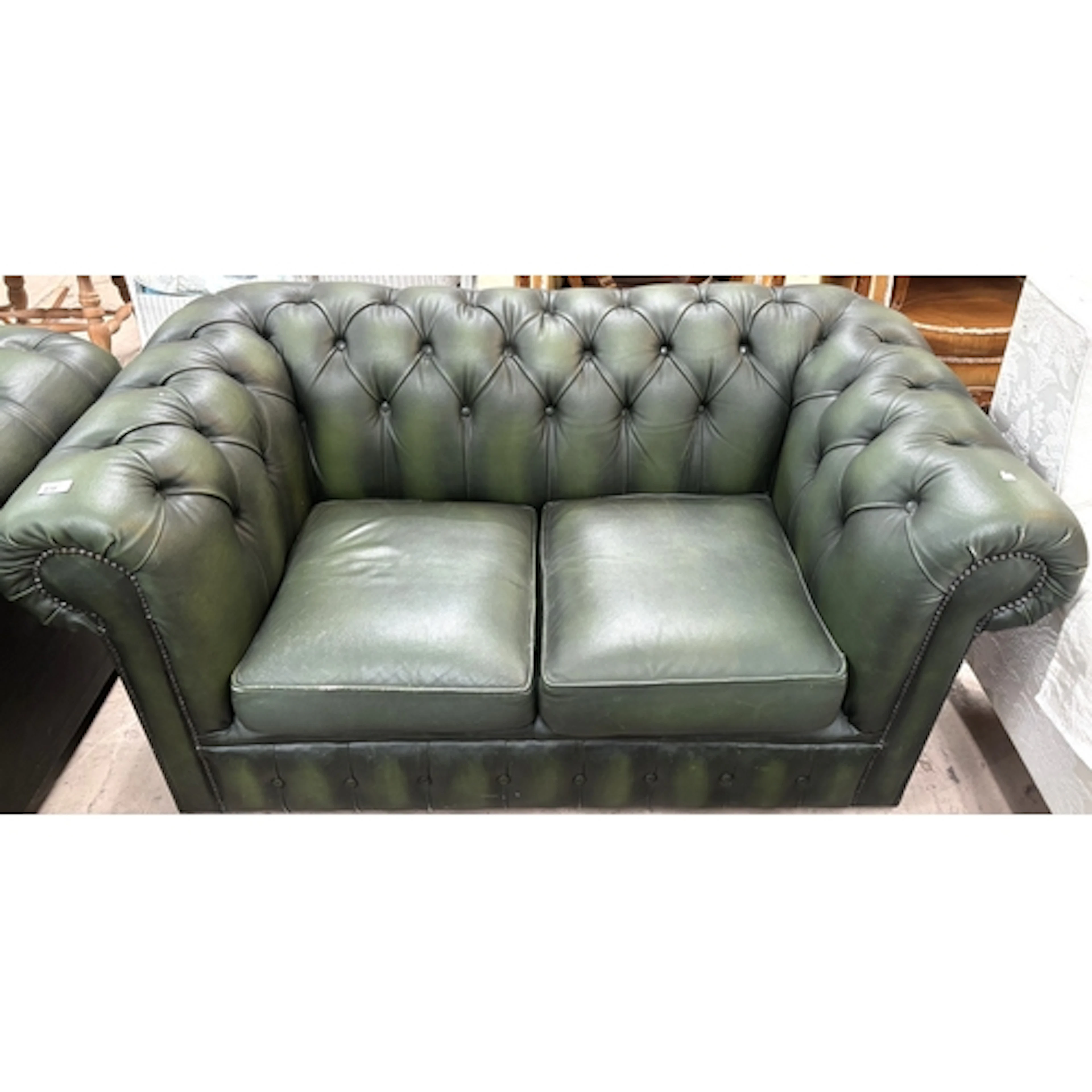 A deeply buttoned 2 seater Chesterfield in green.