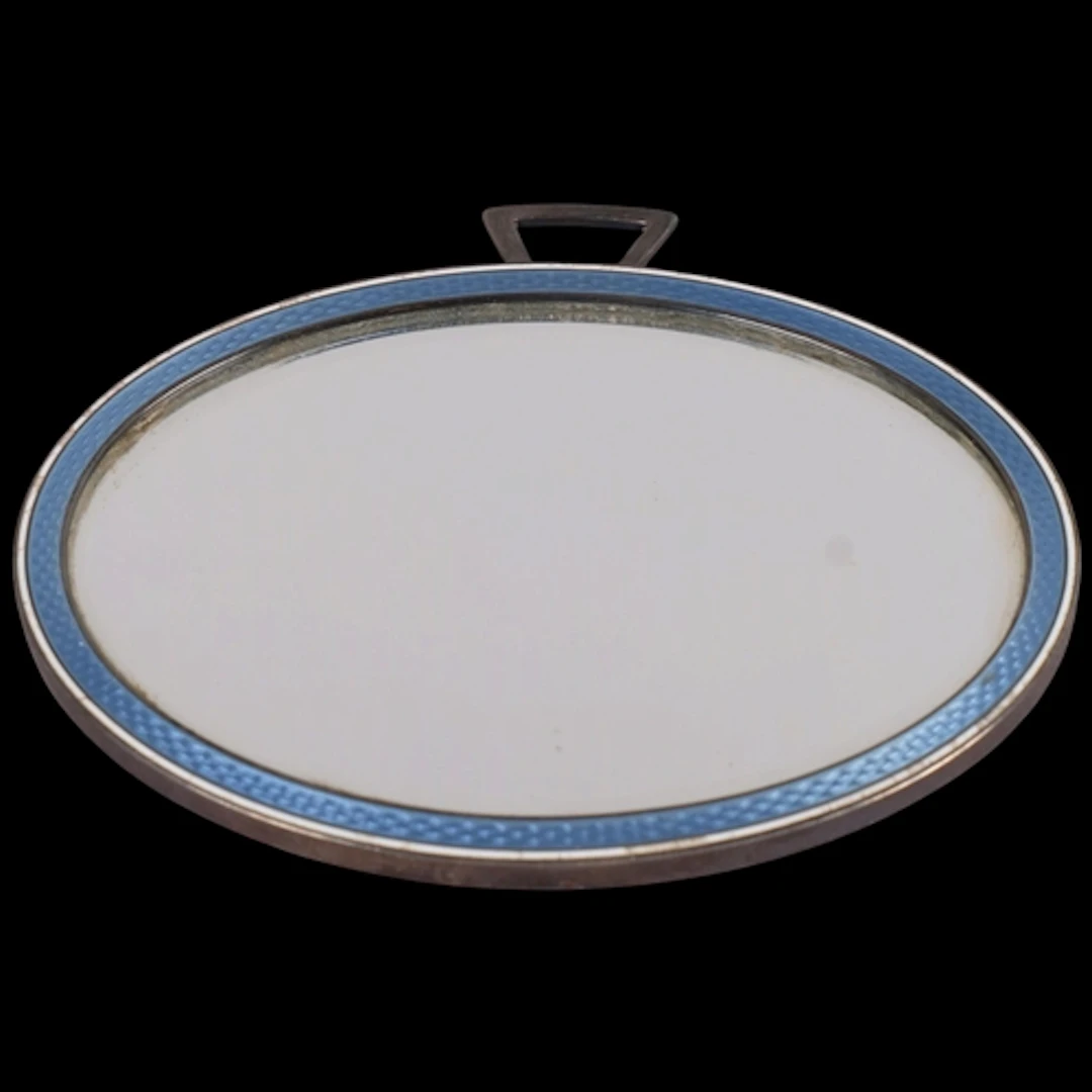 An Art Deco French silver and enamel miror, oval form, with ...