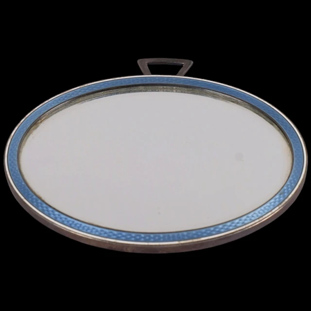 An Art Deco French silver and enamel miror, oval form, with ...