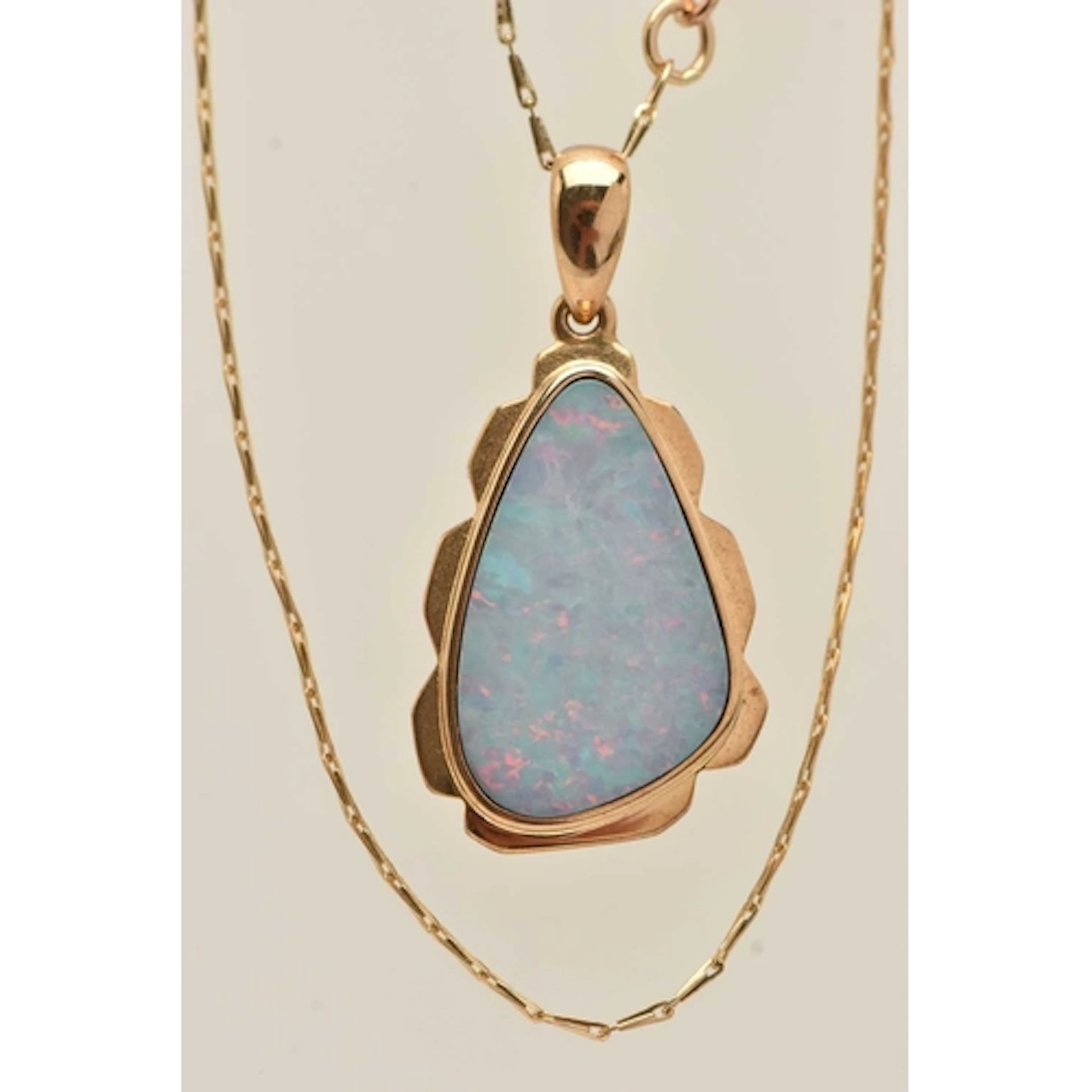A YELLOW METAL OPAL PENDANT NECKLACE, the pendant with wavy ...