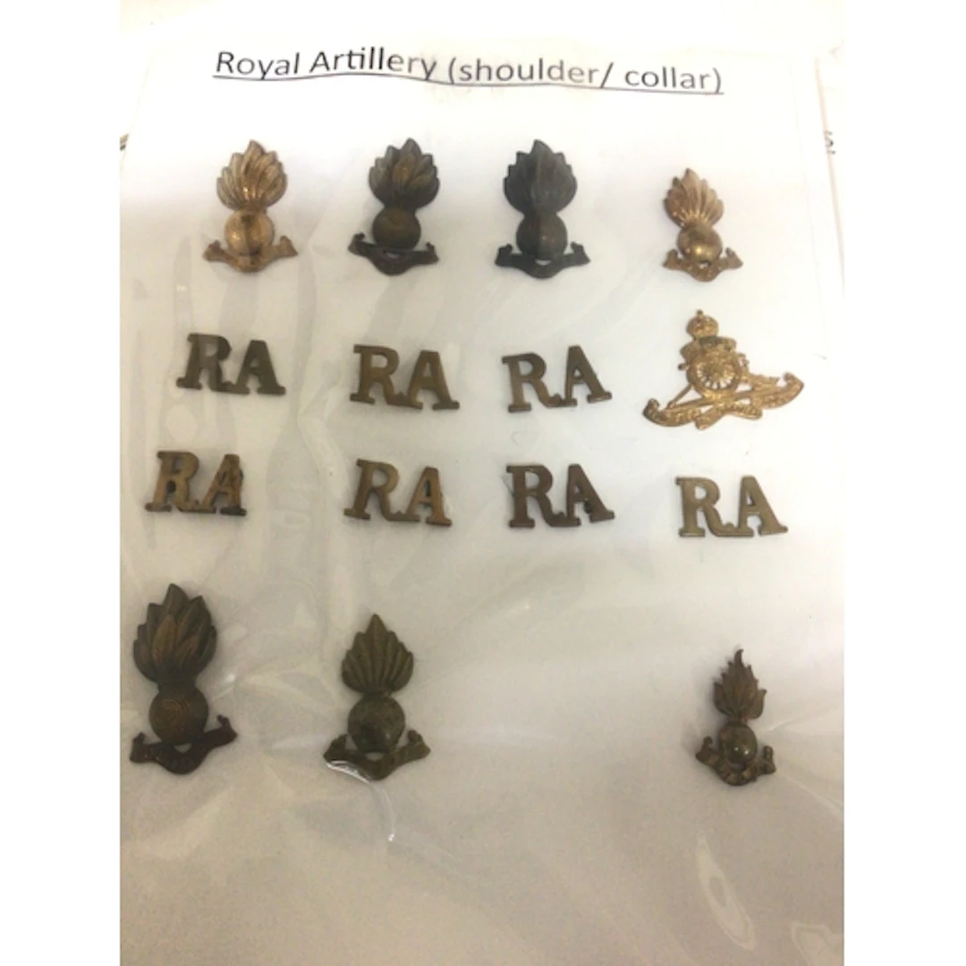 A collection of British Military hat badges in a folde...