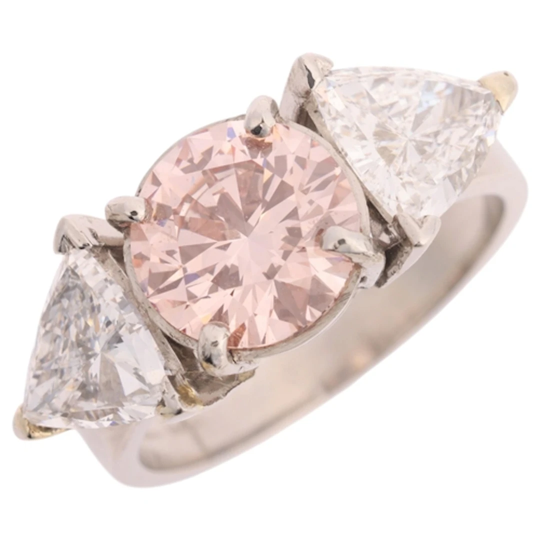 A platinum three stone lab-grown pink diamond and diamond ri...