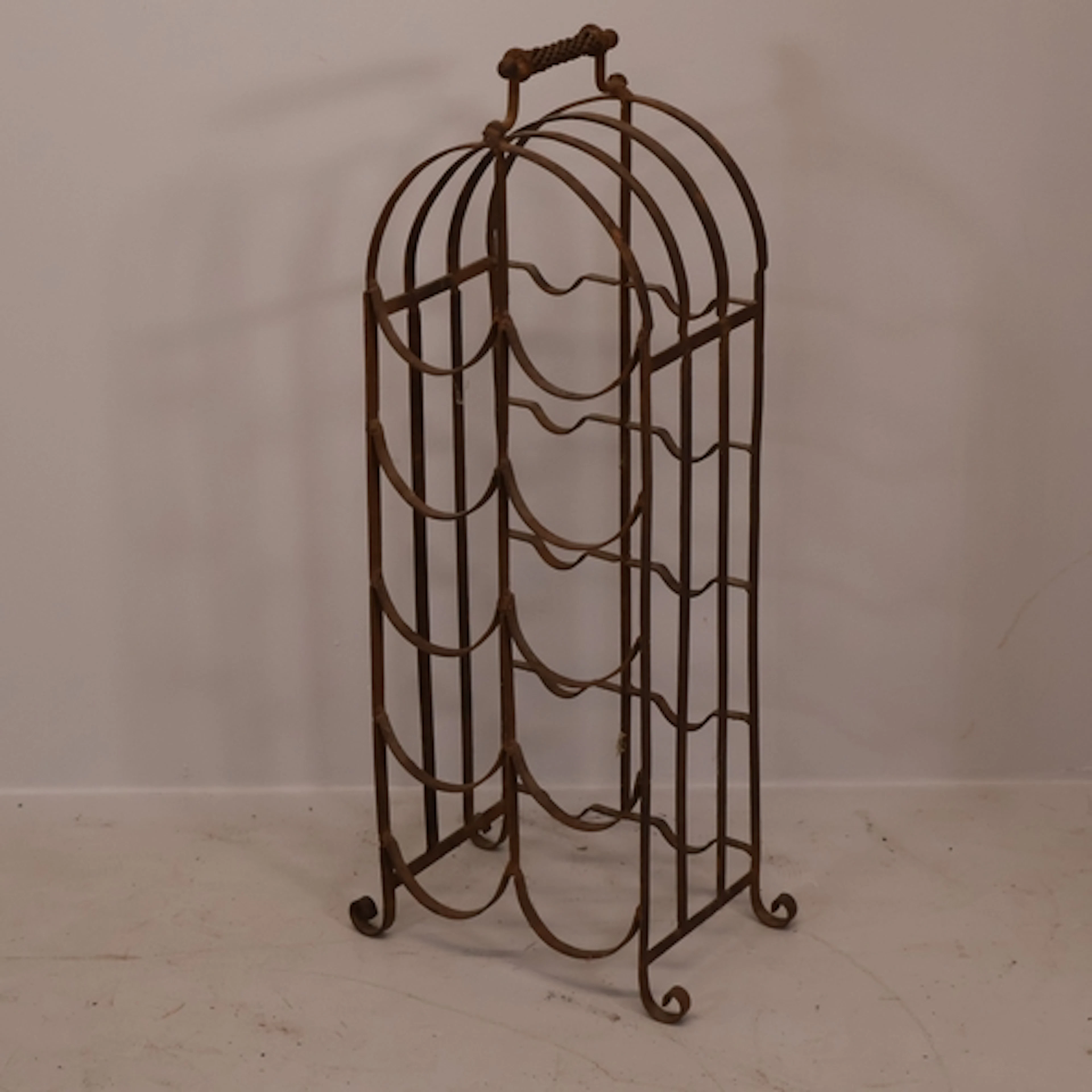 A vintage wrought iron ten-bottle wine rack. H70cm.