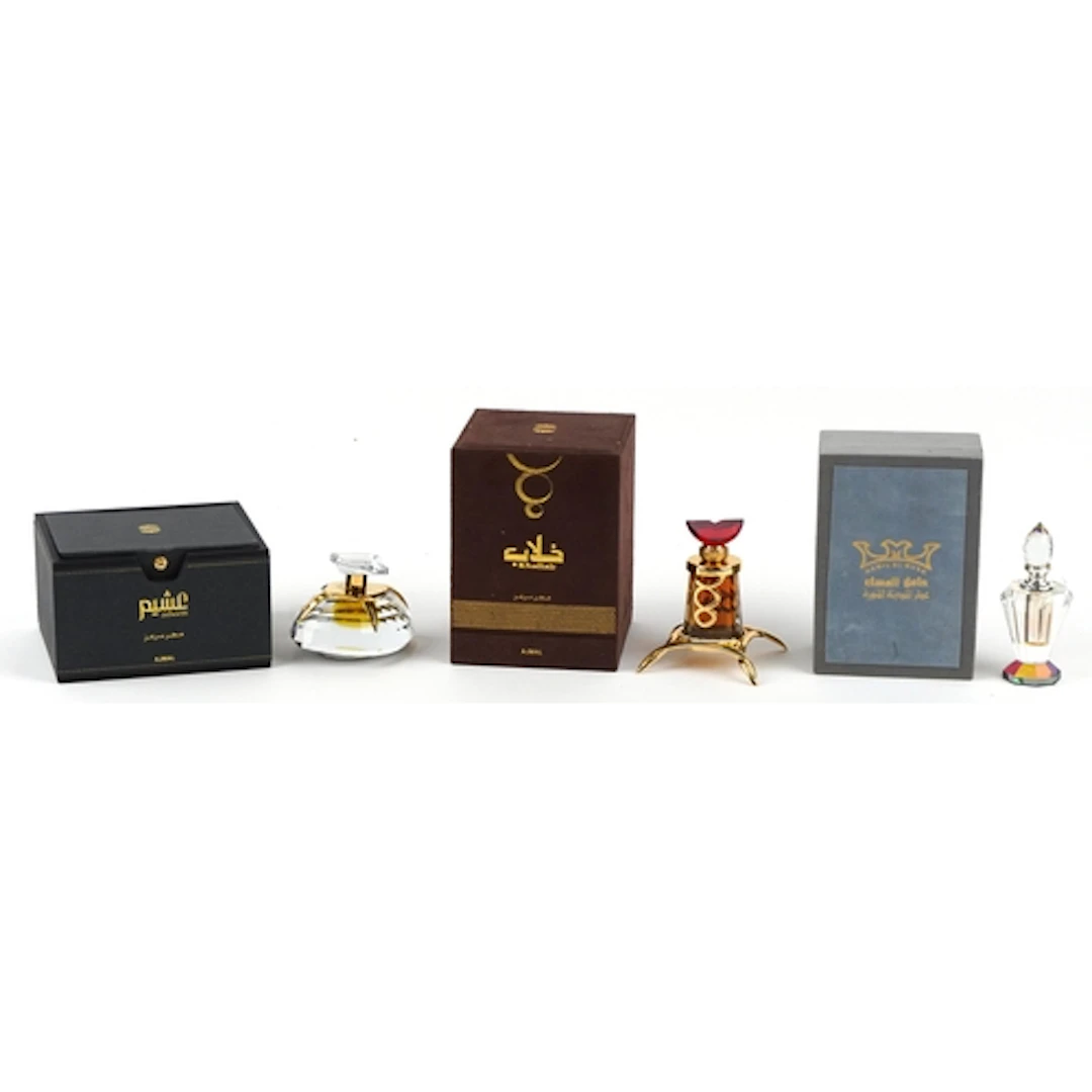 Three Ajmal perfume bottles with some contents and fitted bo...