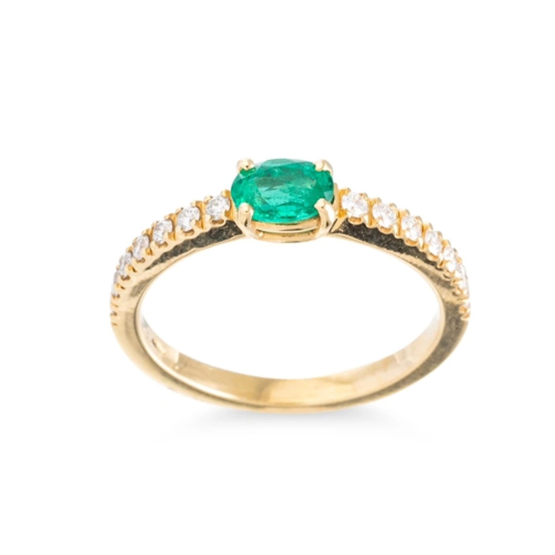 AN EMERALD AND DIAMOND SET BAND RING, the central oval cut e...