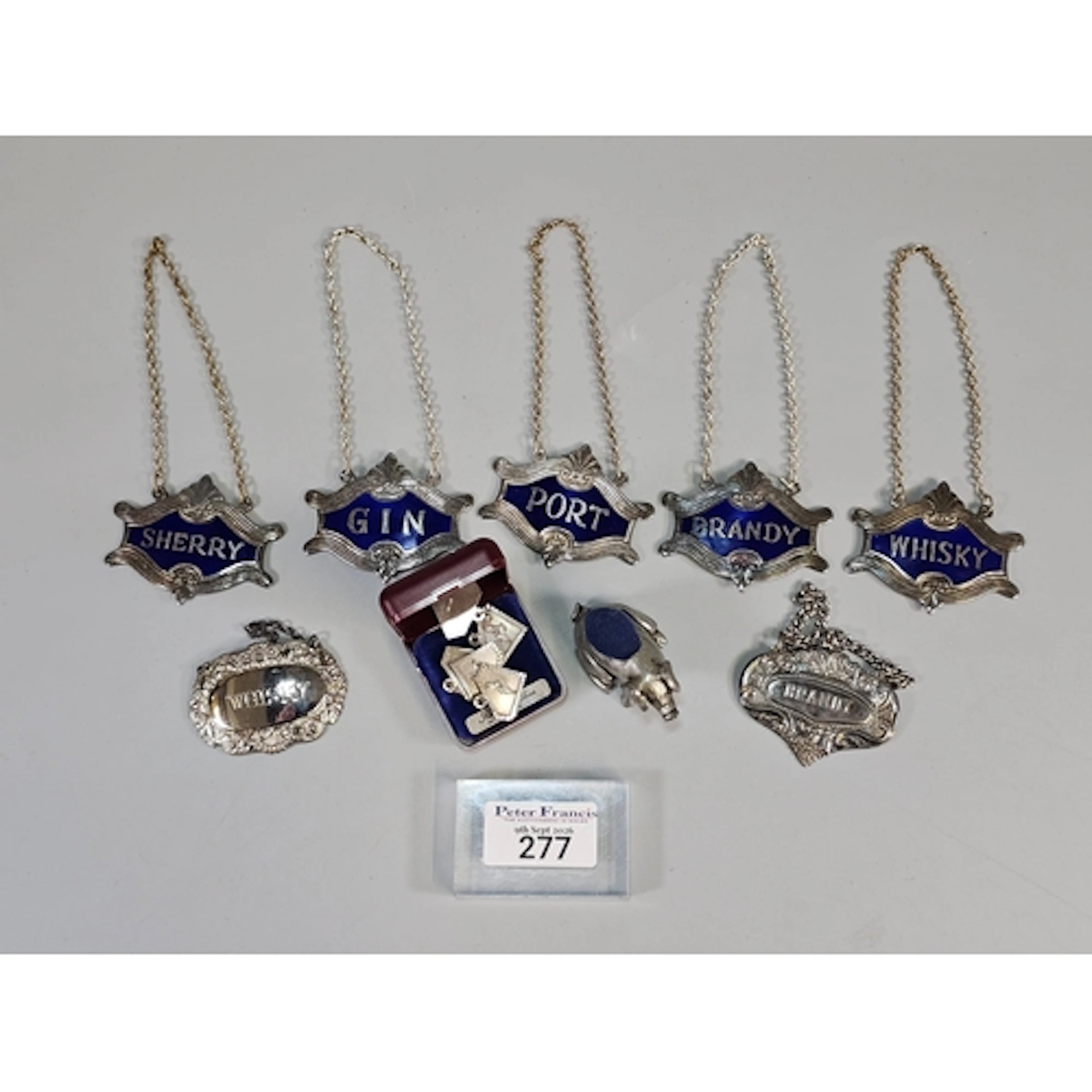 Collection of silver plated and enamel spirit decanter label...