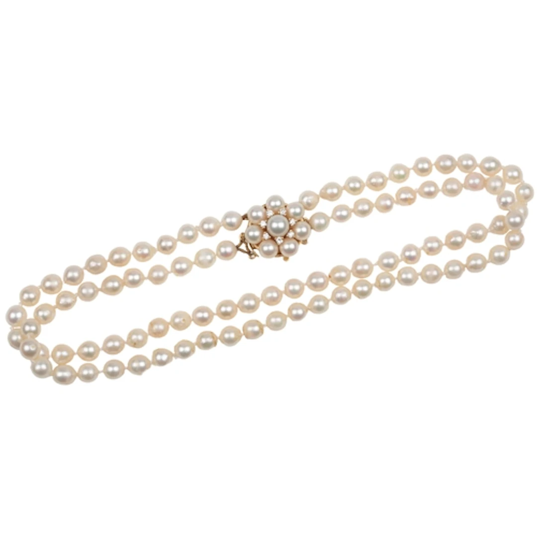 A cultured pearl and diamond necklace, composed of two stran...