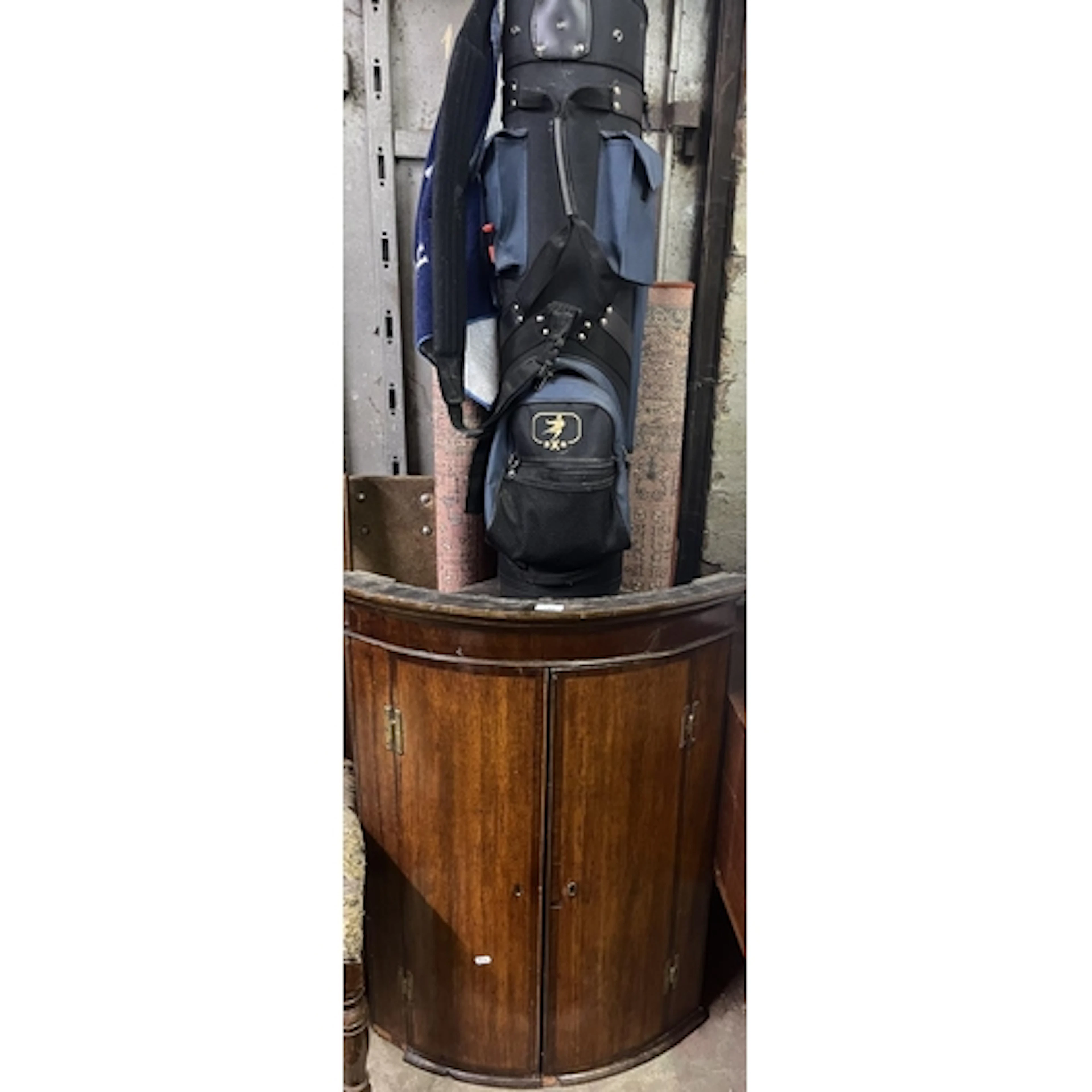 Antique oak corner cupboard, golf clubs and a red ground rug...