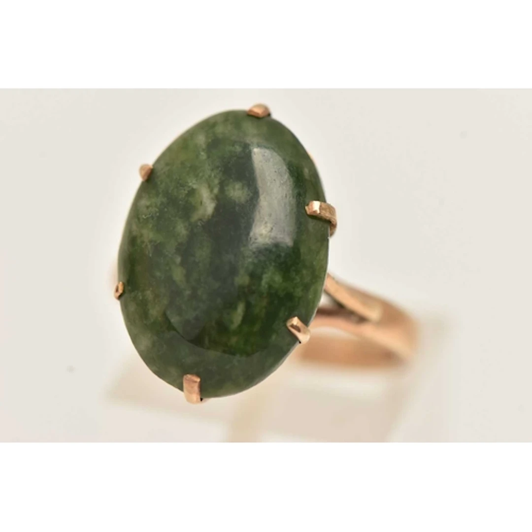A YELLOW METAL NEPHRITE RING, set with a nephrite oval caboc...