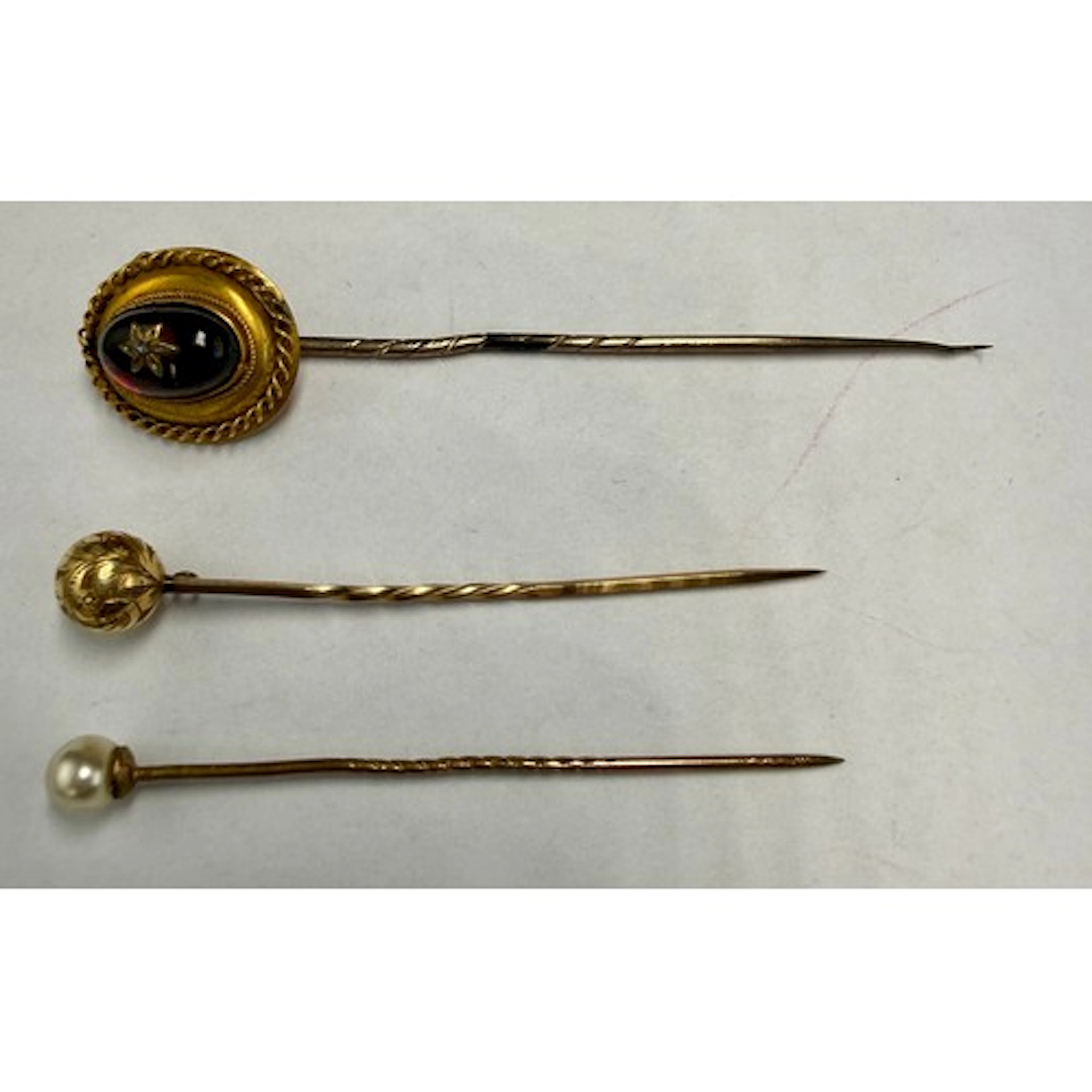 Three 19thC tie pins to include one pink cabouchon set with ...