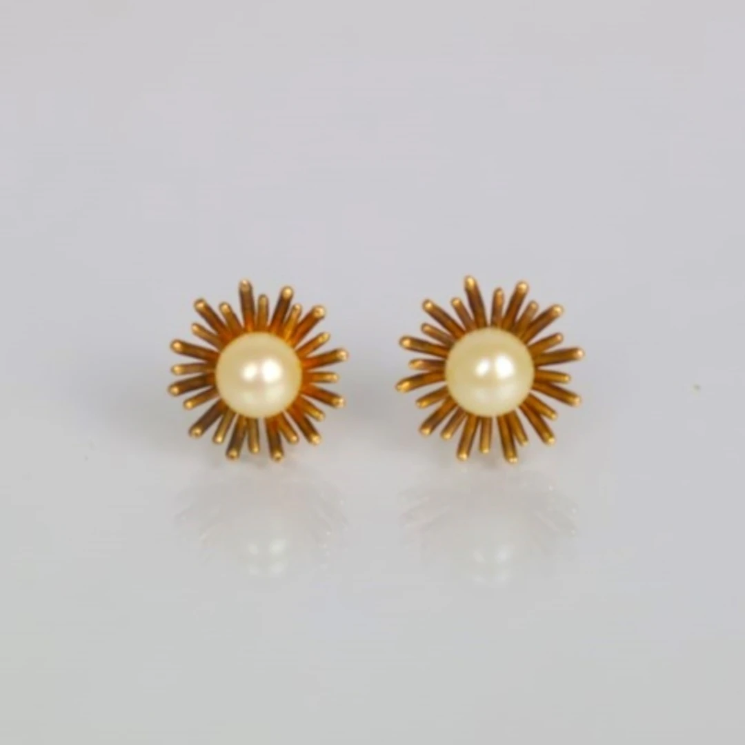 A pair of cultured pearl earrings, the pearls within a yello...