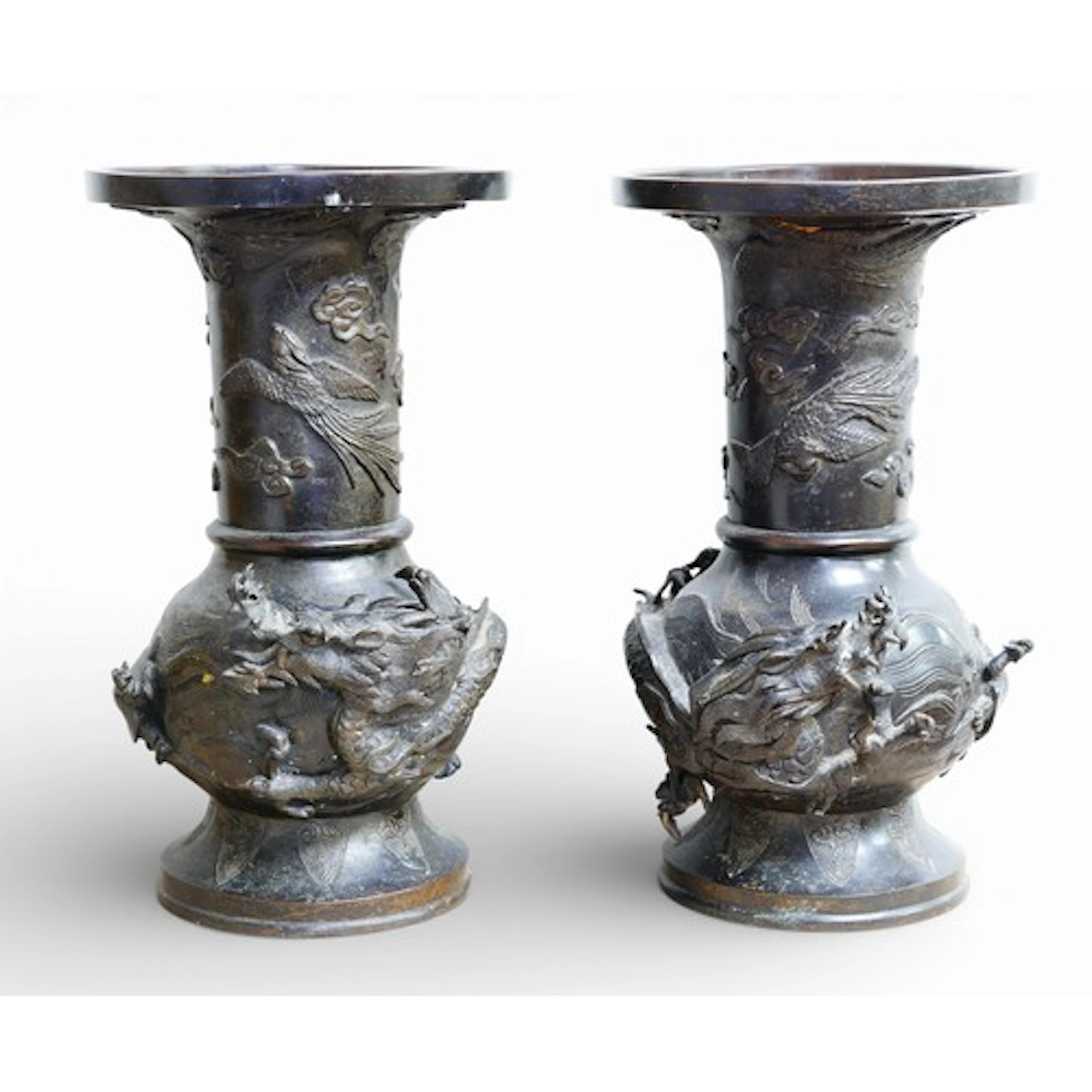 A pair of Oriental bronze dragon urns, each decorated in hig...
