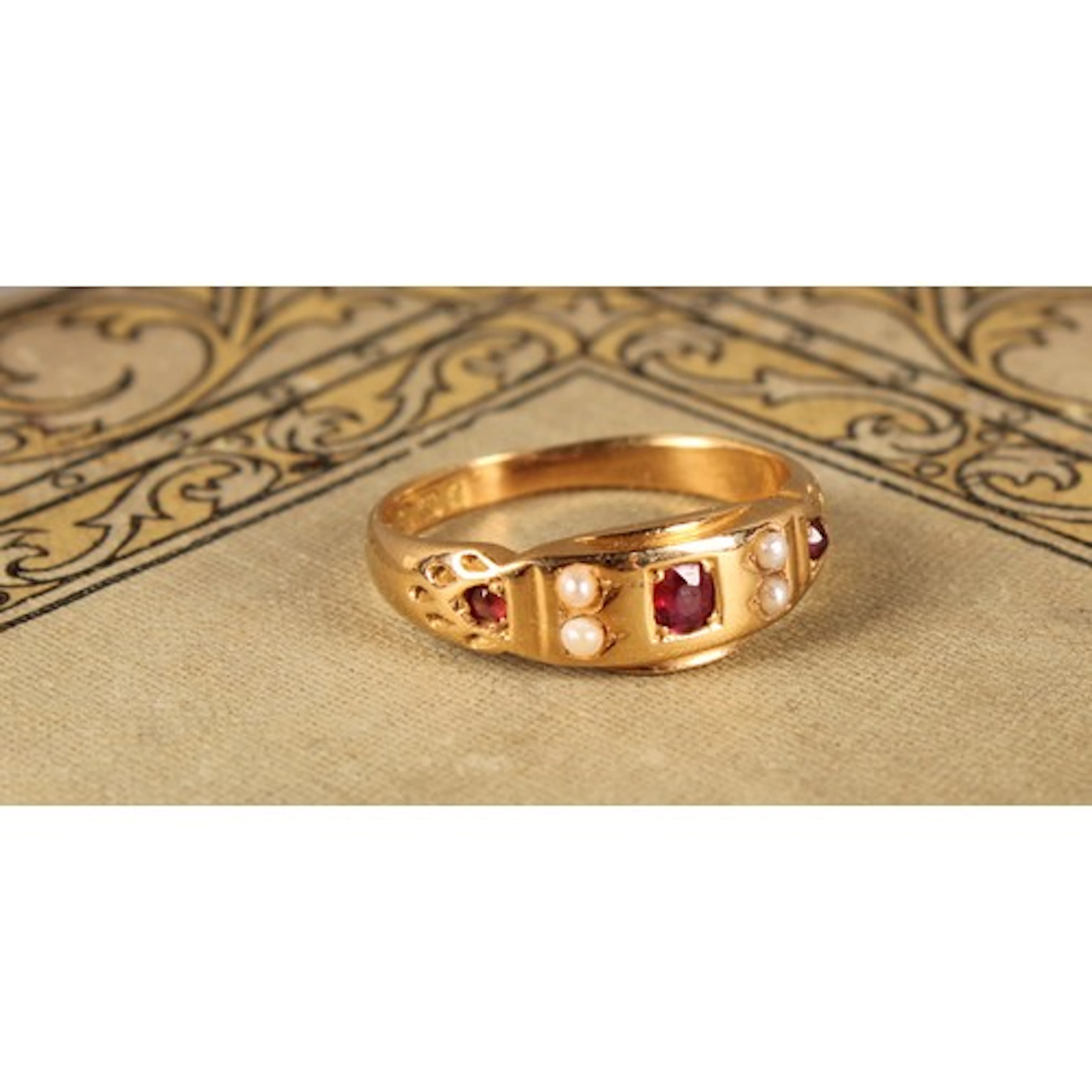 An Edwardian 18ct gold ruby and seed pearl ring, in the Goth...