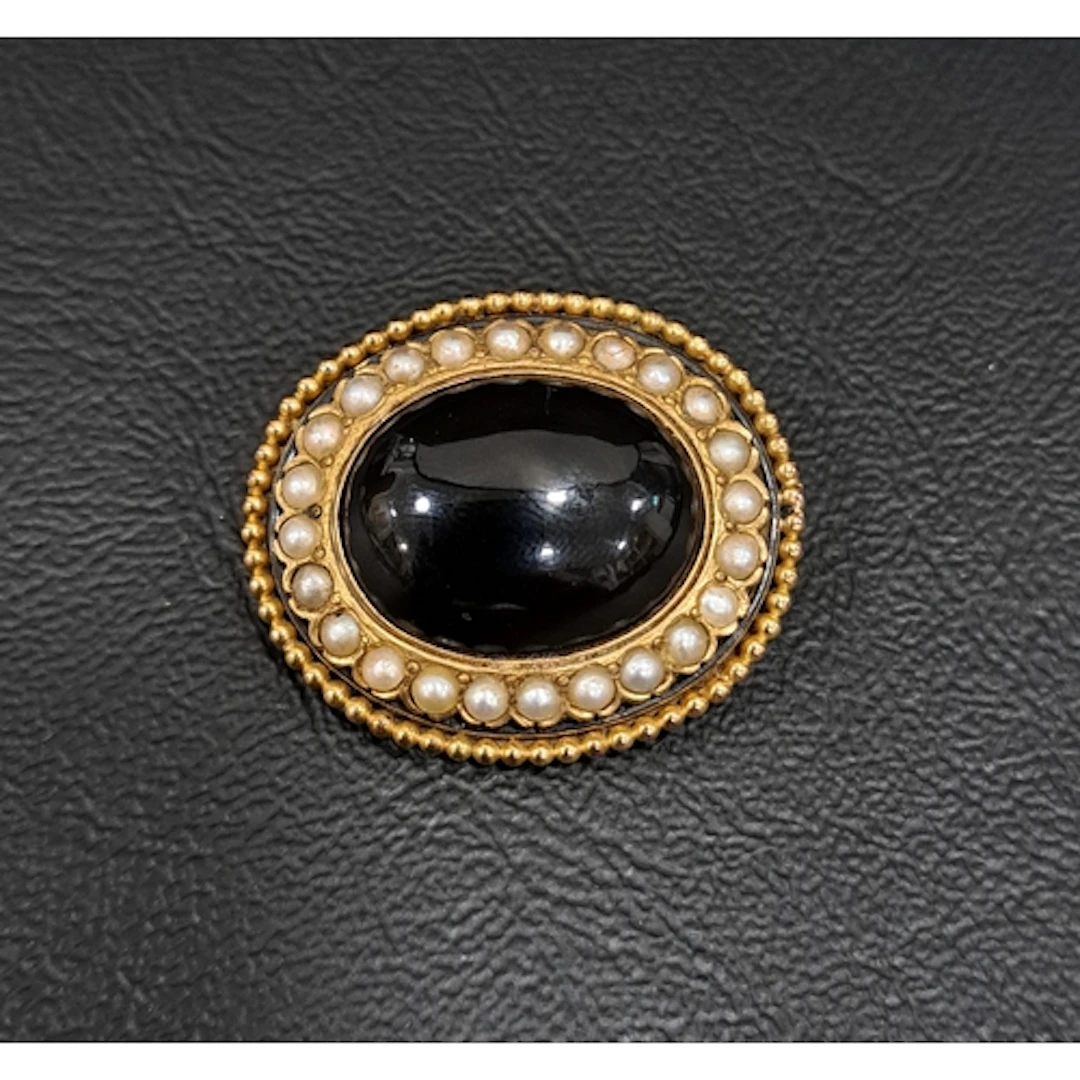 VICTORIAN MOURNING BROOCH the central oval cabochon black on...