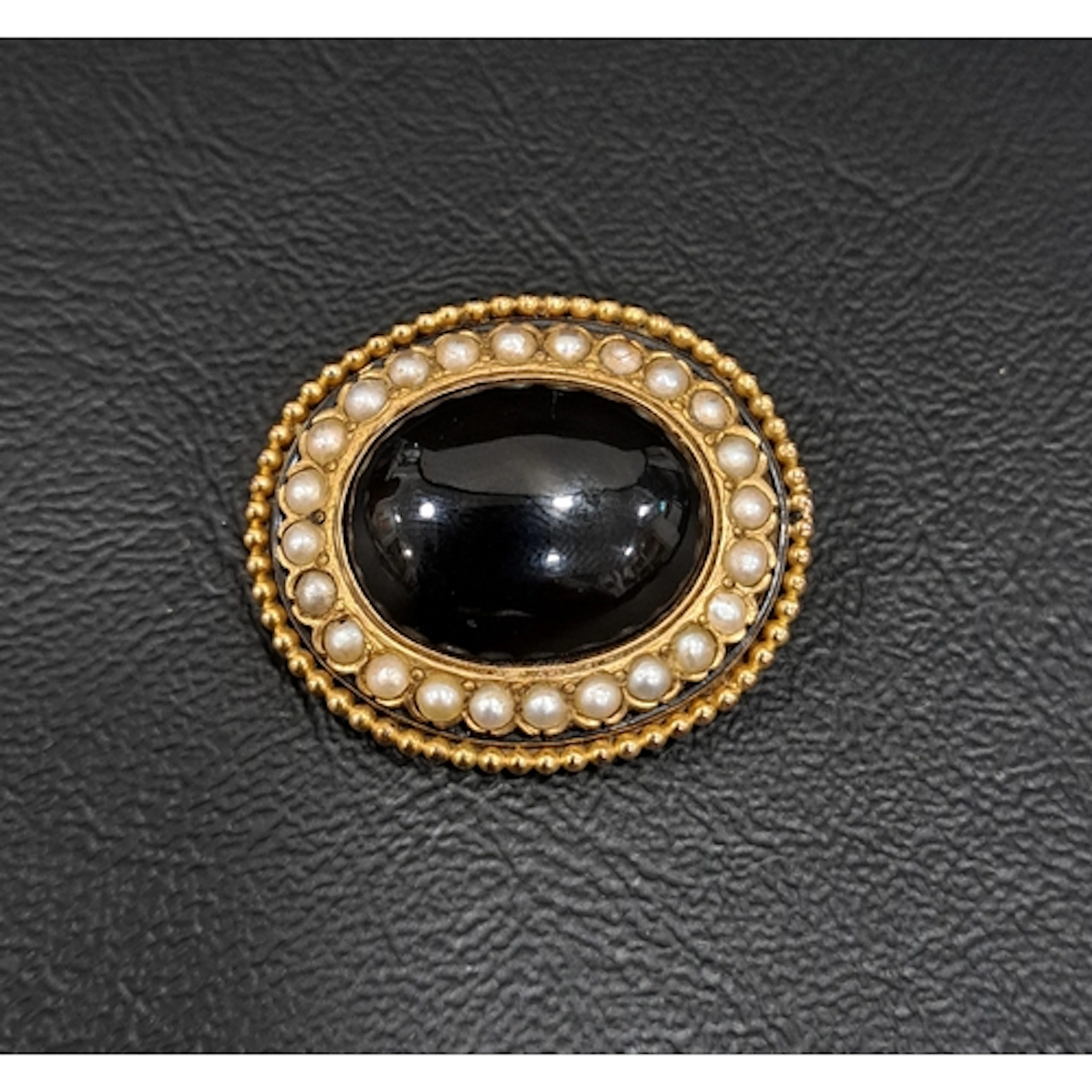 VICTORIAN MOURNING BROOCH the central oval cabochon black on...