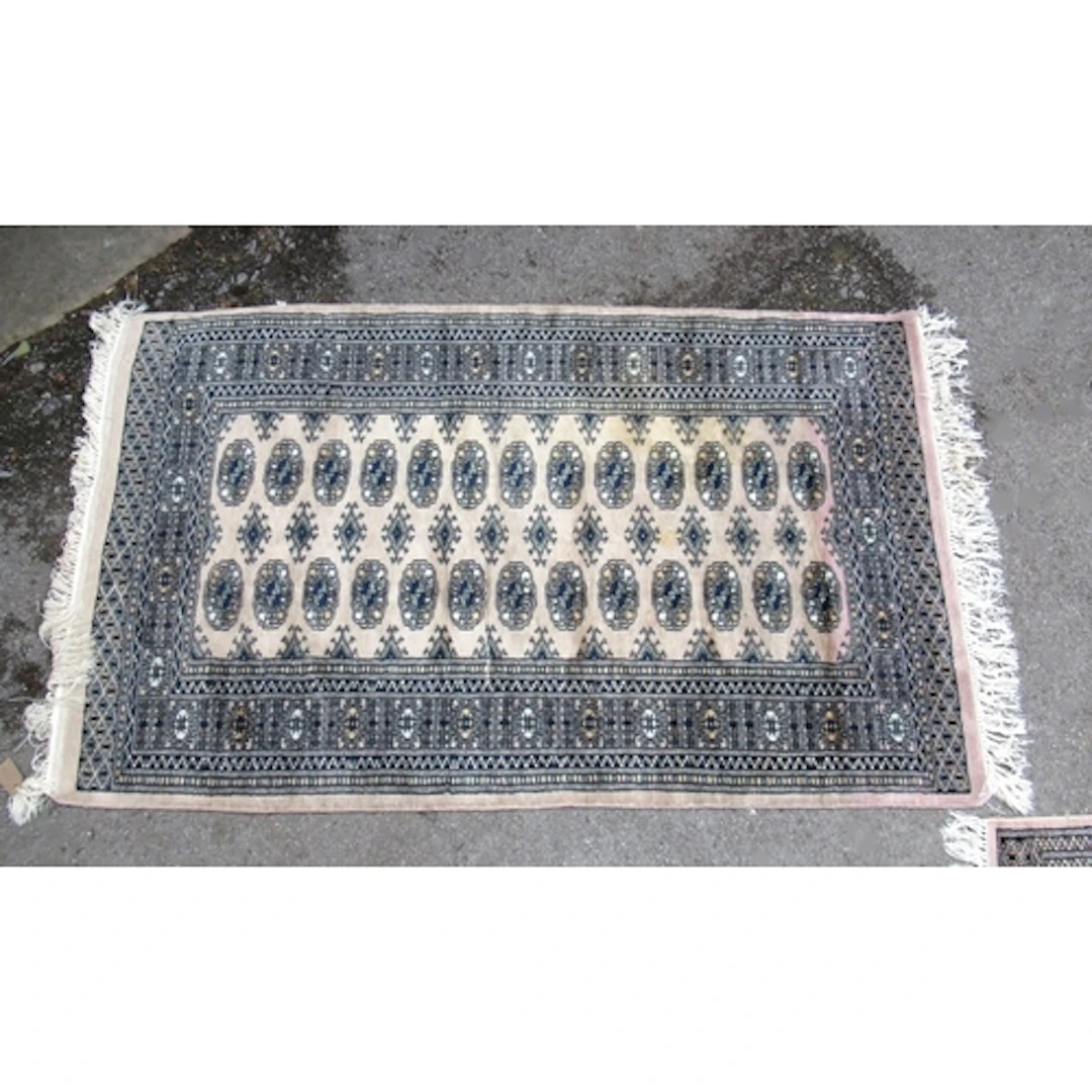 Two Pakistan Bokhara pattern rugs, on beige ground