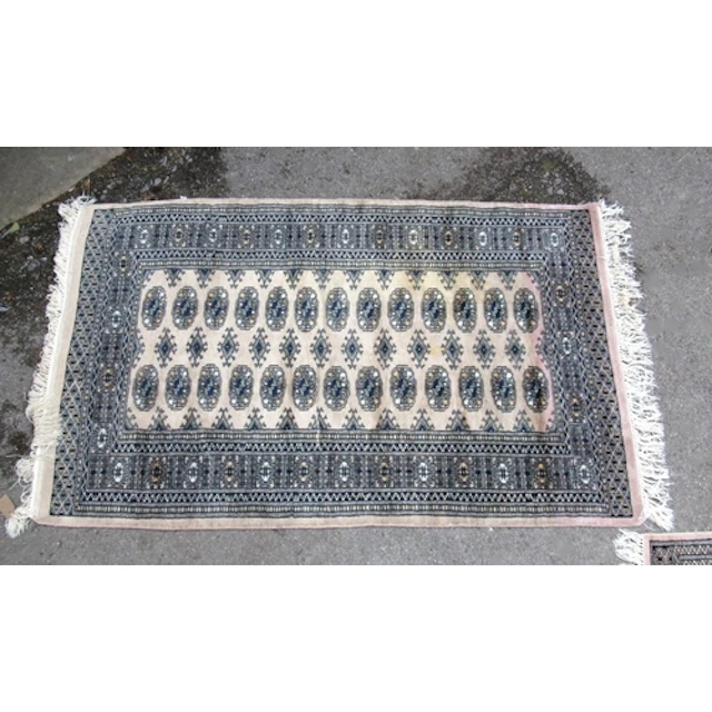 Two Pakistan Bokhara pattern rugs, on beige ground