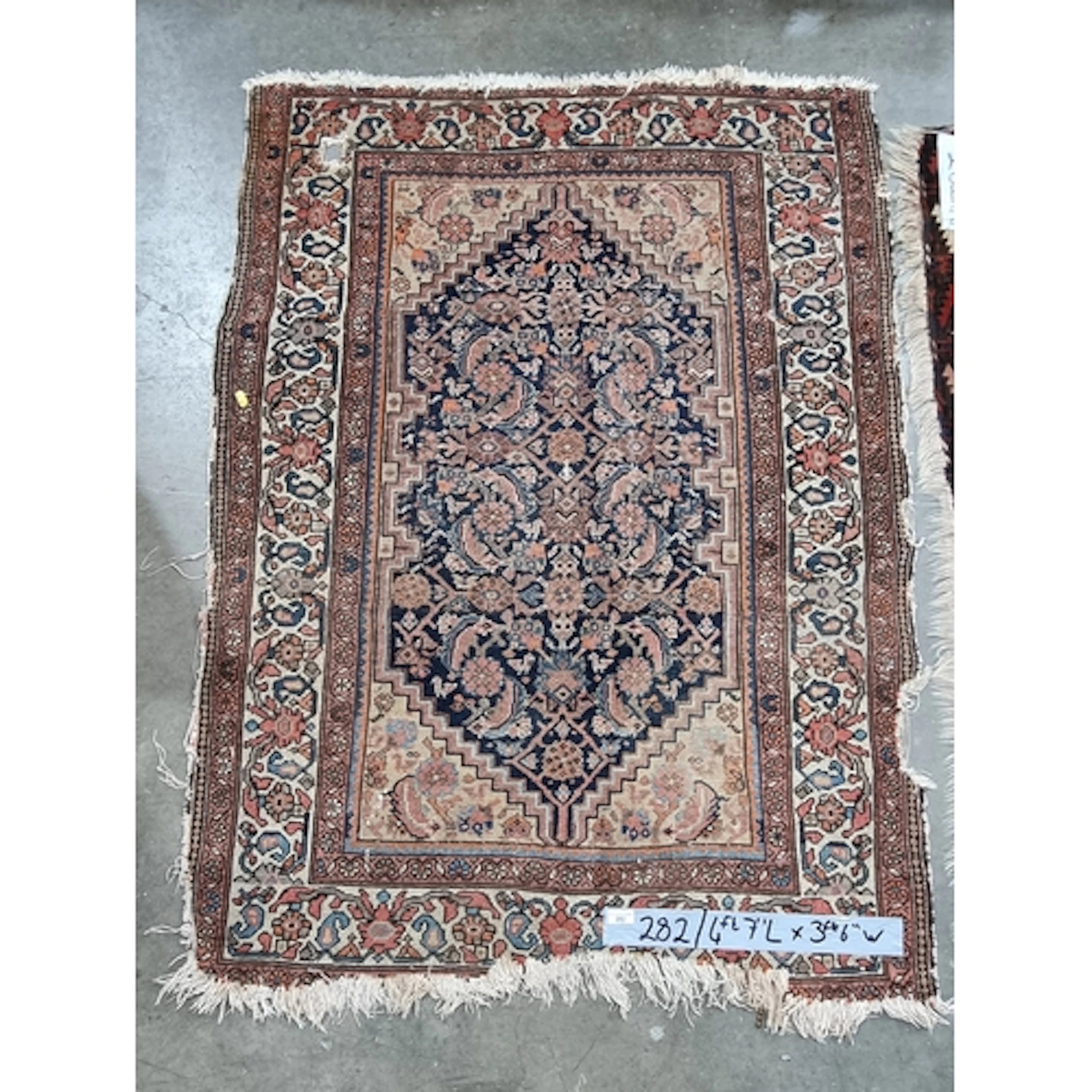 A Persian Rug with floral borders 4ft 7in x 3ft 6in A/F and ...